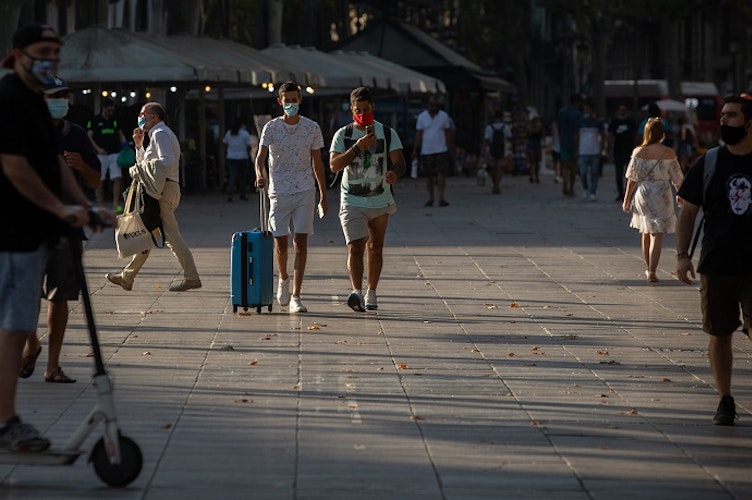 Menschen, manche von denen mit Mundschutz, gehen auf der langen Promenade La Rambla entlang. Deutschland rät wegen regional steigender Infiziertenzahlen von Reisen nach Katalonien mit der Touristenmetropole Barcelona ab. Foto: Europa Pressdpa