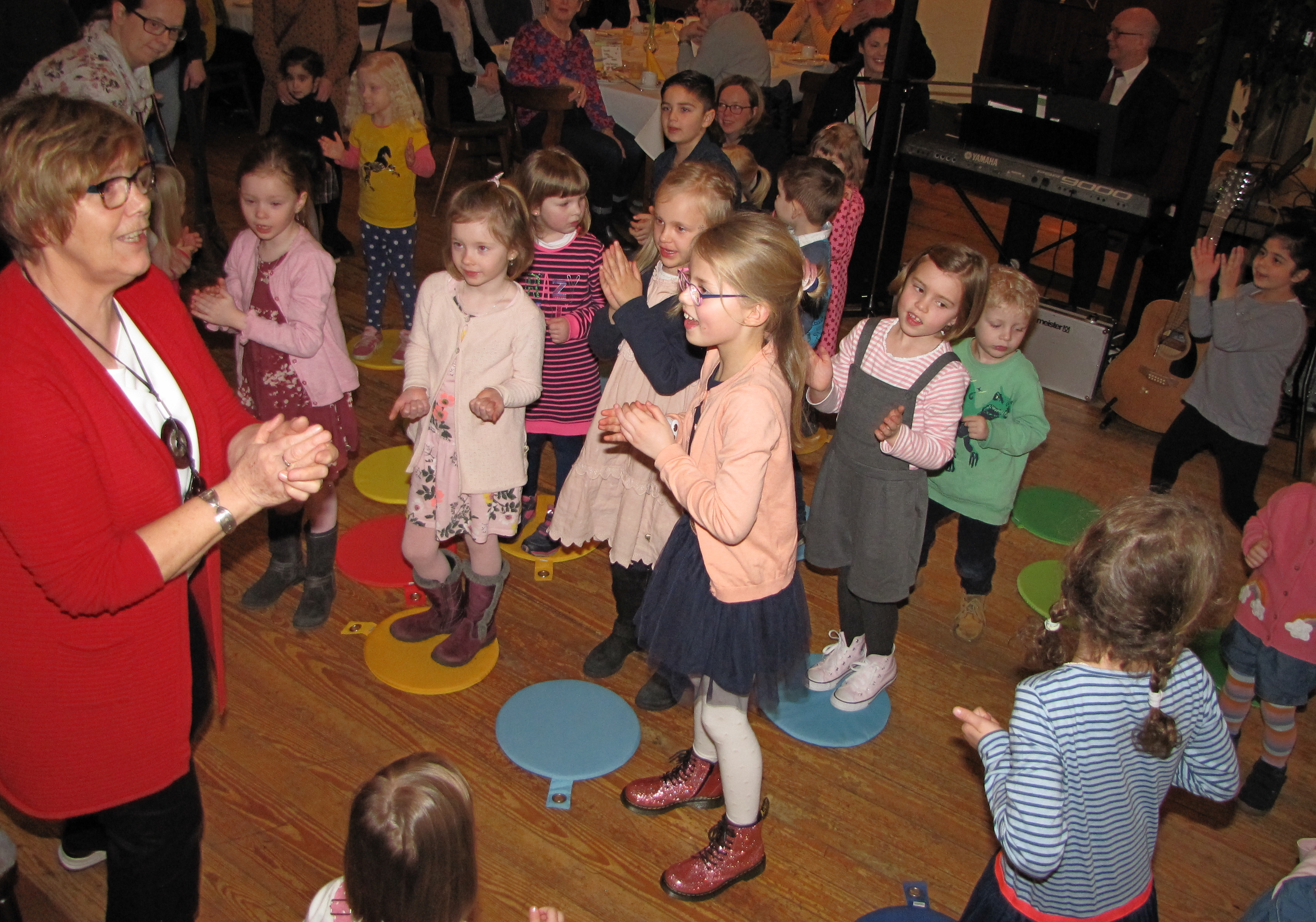 Spielerisch zum Plattdeutschen: Gertrud Grotegers (vorne links) vermittelt den Kindergartenkindern mit Fingerspielen und leicht verständlichen Liedern die niederdeutsche Sprache. Foto: Röttgers