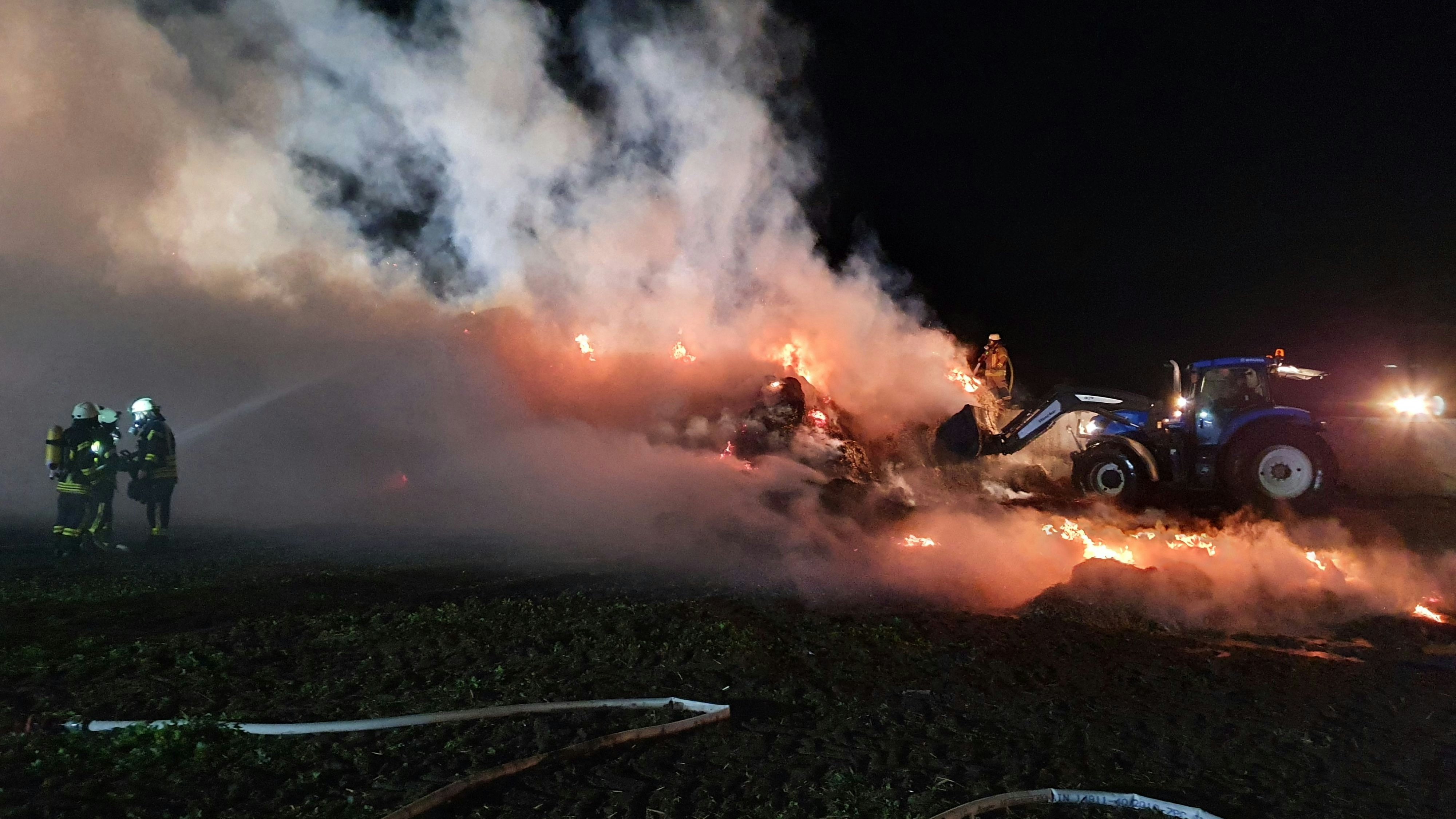 Mit Teleskoplader und Trecker wurden die brennenden&nbsp;Rundballen abgetregen und ausgebreitet. Fotos: Feuerwehr Lutten/Richter