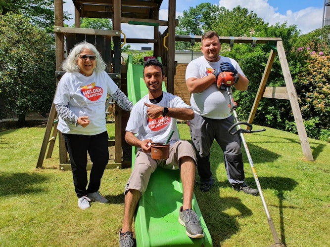 Bringen das Klettergerüst auf Vordermann (von links) Mina Amiri, Shamroz und Alexander Stoll beim Projekt Pimp up your garden. Foto: Kessens