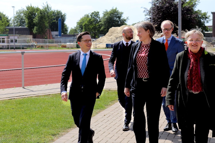 Minister Falko Mohrs (links) beim gemeinsamen Rundgang über den Campus. Im Hintergrund ist die Baustelle für den neuen Sportcampus der Universität Vechta zu sehen. Foto: Universität VechtaSchmidt