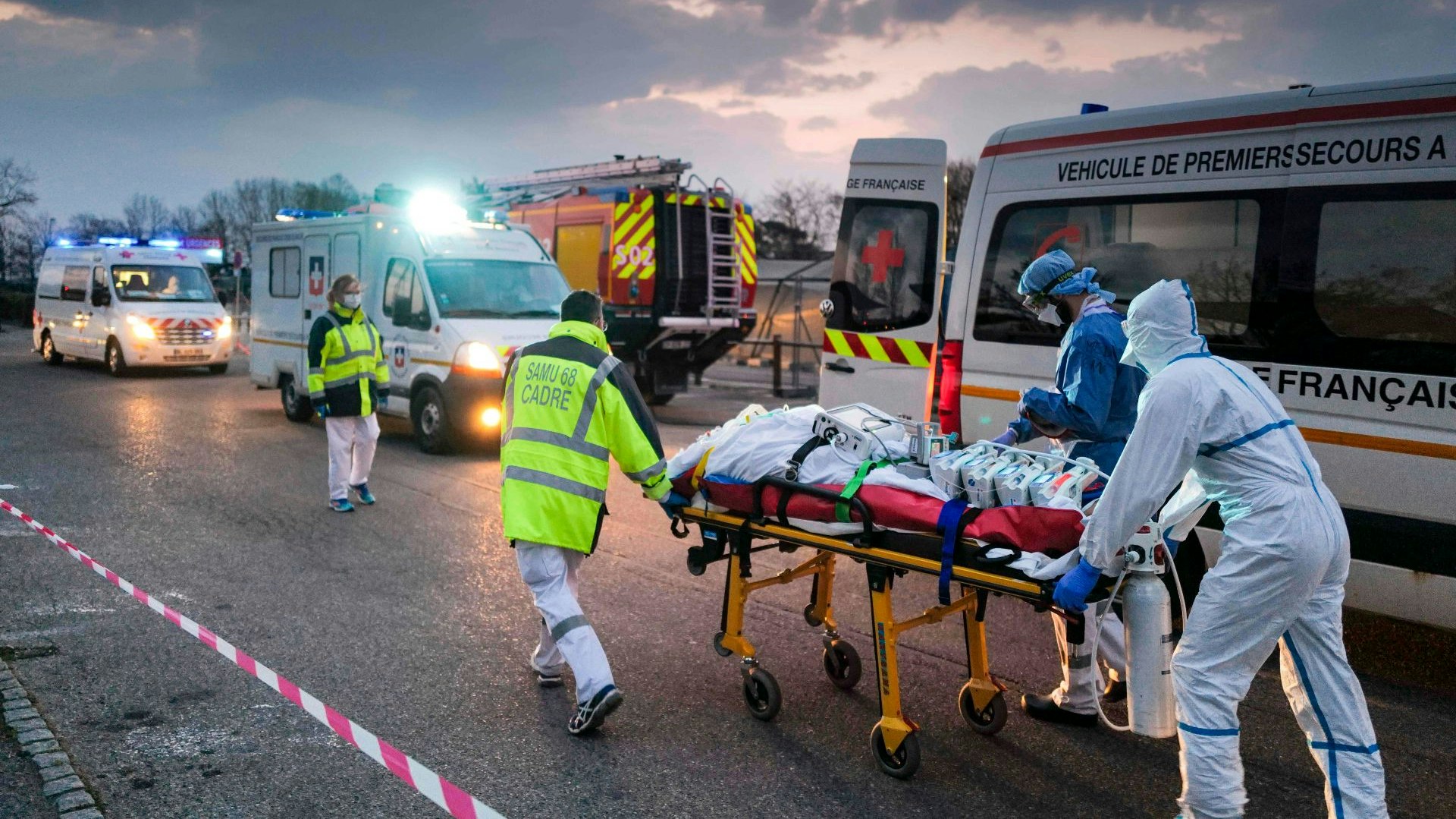 Medizinisches Notfallpersonal transportiert einen Patienten, der mit dem Coronavirus infiziert ist, von einem Militärkrankenhaus in Mulhouse zu einem Rettungswagen. Im Anschluss wird der Patient mit einem Hochgeschwindigkeitszug in eine andere Klinik verlegt. Foto: dpa/Bozon