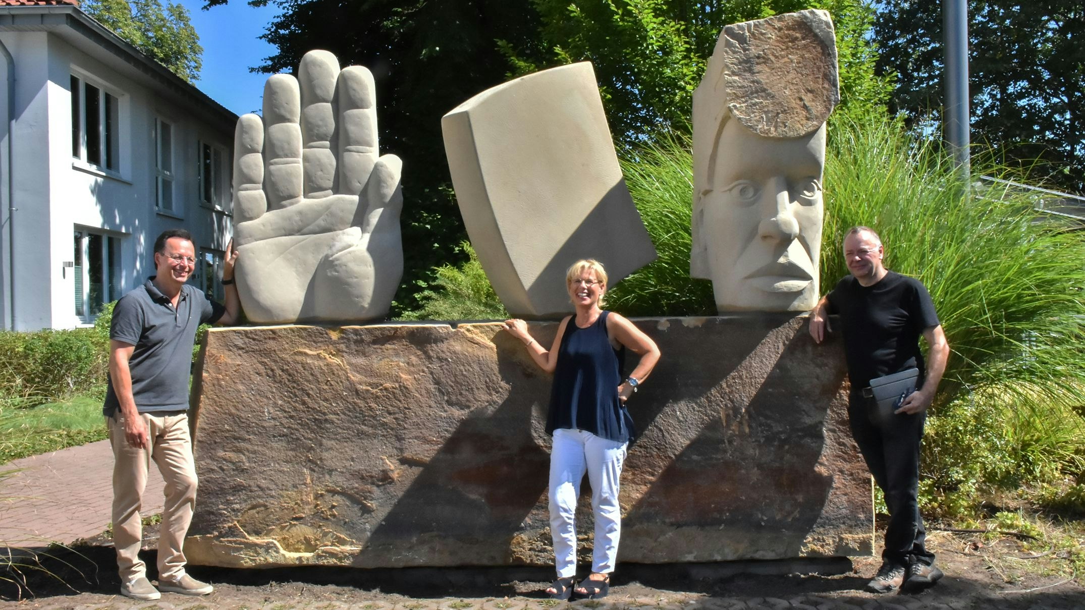 Es ist vollbracht: Bildhauer Jürgen Waxweiler (rechts) übergibt das Kunstwerk an die Unternehmer-Familie Nils und Sabine Bogdol. Foto: Vollmer