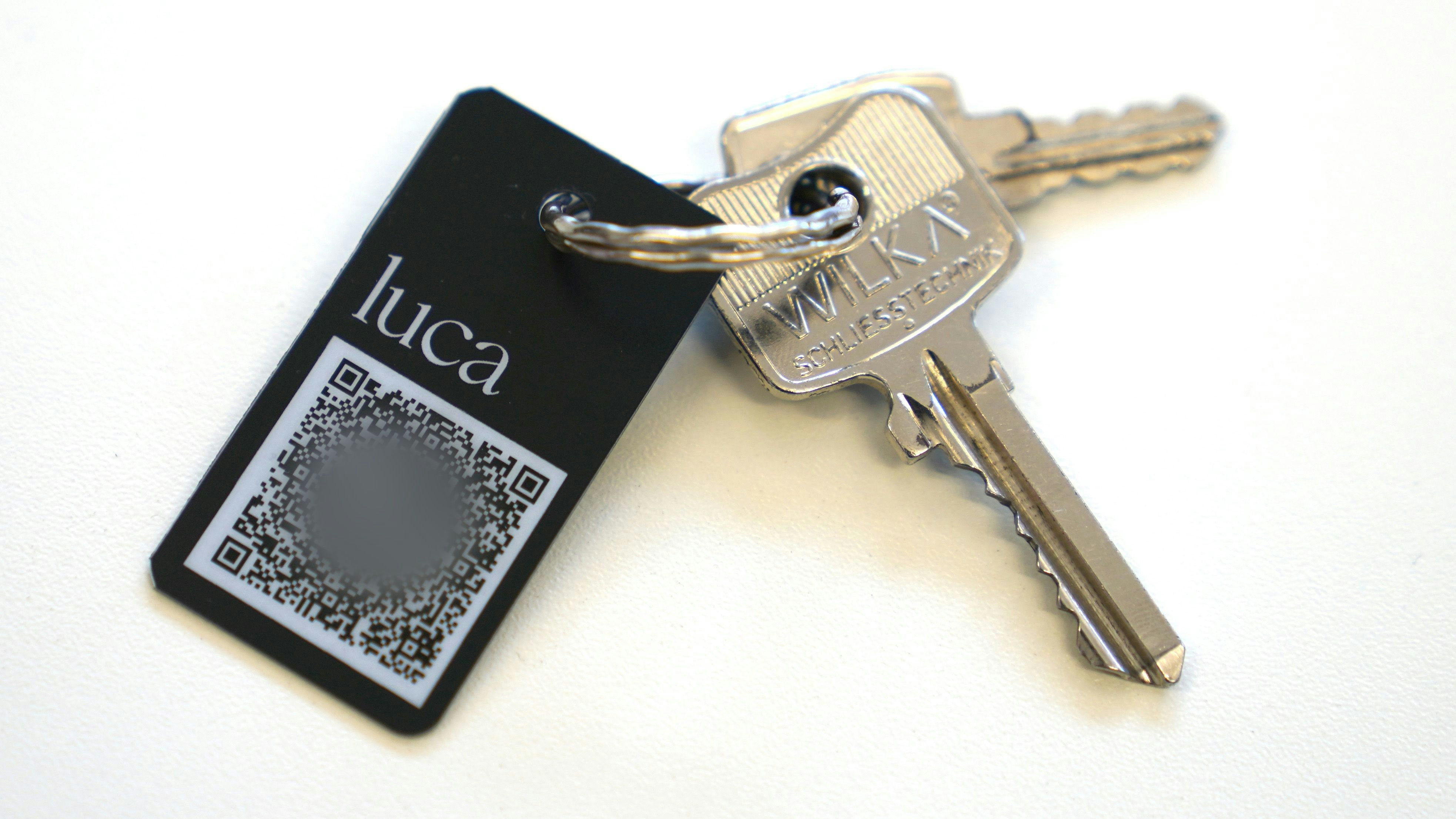 Ein Schlüsselanhänger mit QR-Code und der Aufschrift "luca" liegt auf einem Tisch. Aus Datenschutzgründen wurde der Code verpixelt. Foto: dpa