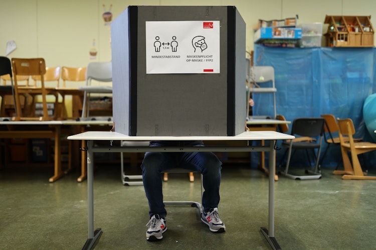  An einer  Wahlkabine weist ein Zettel auf die Corona-Regeln hin. Foto: dpa