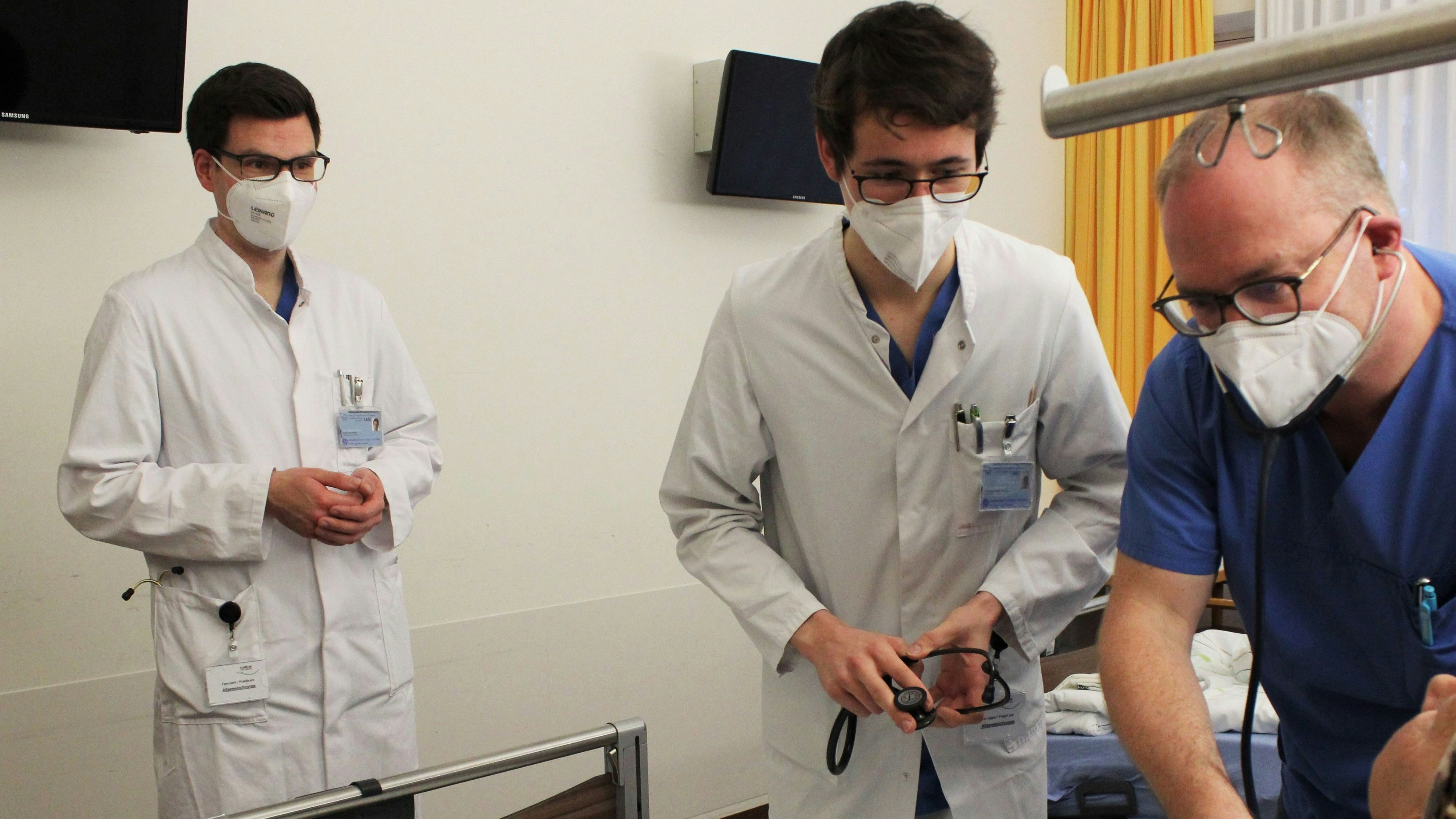 Dr. Steffen Neumann (r) unterrichtet die Medizinstudenten der UMG, Martin Strohmeyer (l) und Maximilian-Martin Lahmer, am Krankenbett einer Patientin im Klinikum Wolfsburg. Foto: dpa