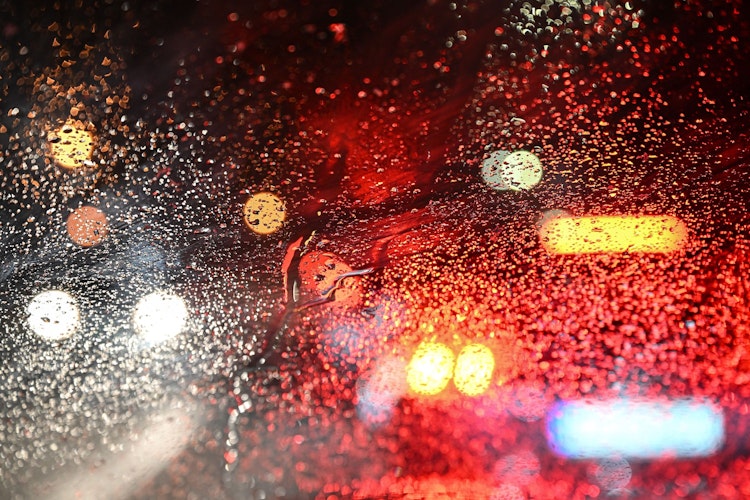 Mehrere Autos stehen auf der Bundesstraße 32 bei Wangen im Allgäu an einem Bahnübergang. Die Wassertropfen auf der Windschutzscheibe brechen die Lichter der Autos. In der Nacht hat es im Allgäu zu Schneien begonnen. +++ dpa-Bildfunk +++