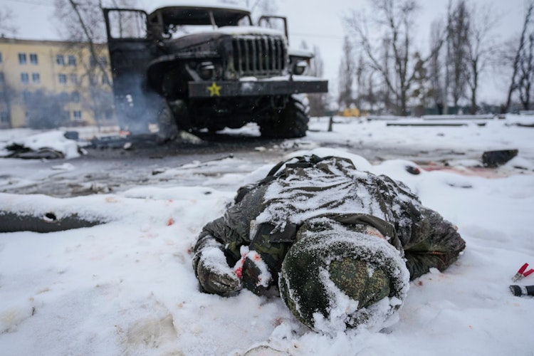 Die Leiche eines Soldaten liegt schneebedeckt neben einem zerstörten russischen Militärfahrzeug mit Mehrfachraketenwerfern am Stadtrand. Foto: dpaAPGhirda