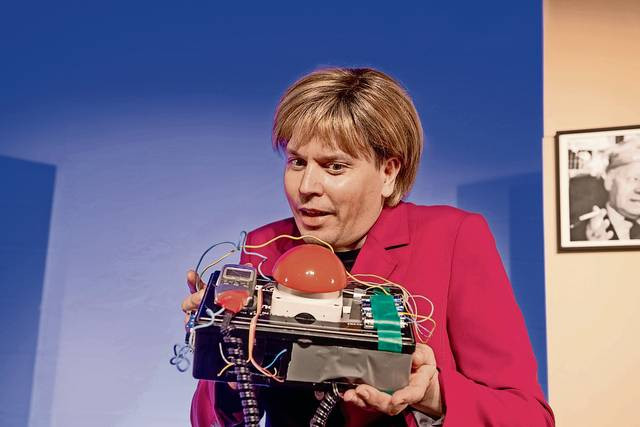 Ab in die Zukunft: Im 150. Bühnenprogramm des Berliner Kabarett-Theaters Distel lässt Angela Merkel (Timo Doleys) eine Zeitmaschine bauen, um ihr Volk in eine sorgenfreie Zukunft zu katapultieren.	Foto: Chris Gonz