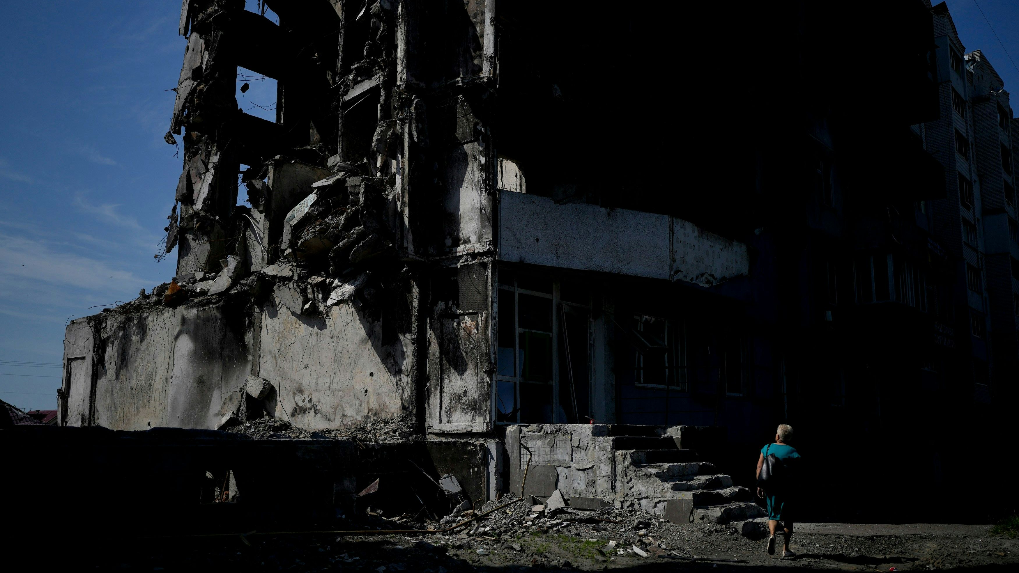 Eine Frau geht an einem durch russischen Beschuss zerstörten Gebäude in Borodjanka am Stadtrand von Kiew vorbei. Foto: dpa