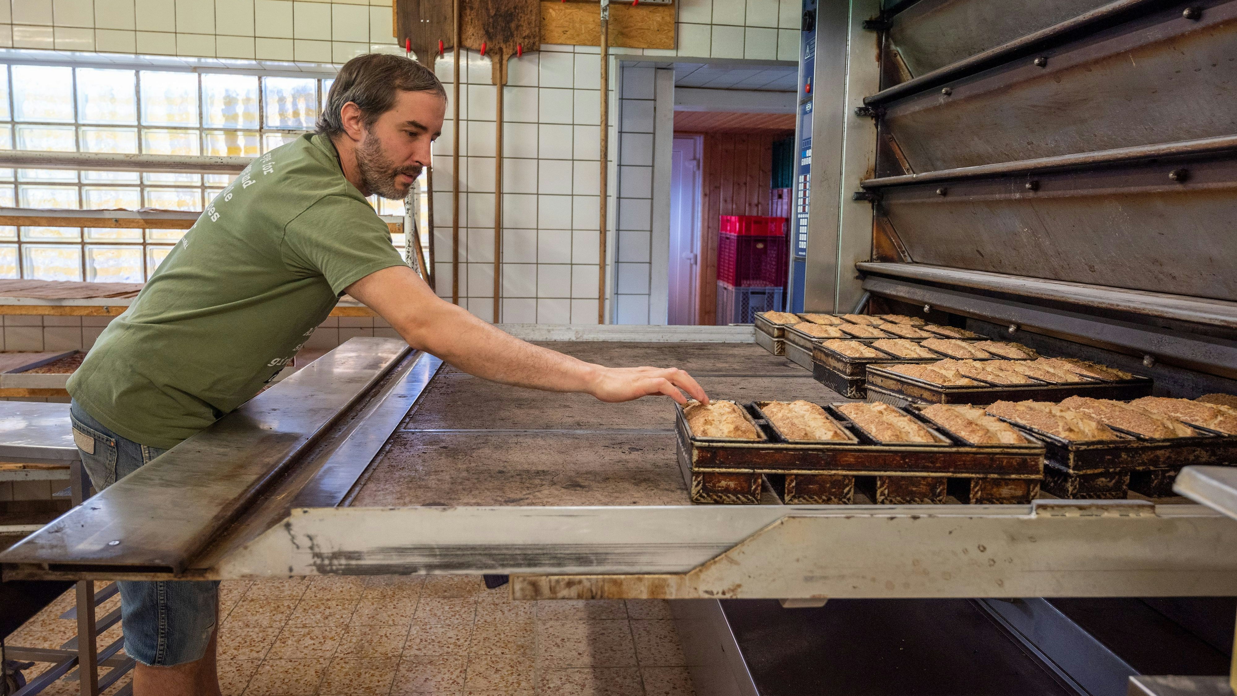 Die Energiekosten sind hoch und steigen weiter: Ein Handwerksbäcker prüft frisch gebackene Brote aus seinem Ofen. Symbolfoto: dpa/Tittel