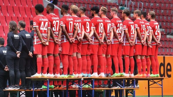 In Reih' und Glied: Der FC Augsburg beim offiziellen Fototermin für die Saison 2022/23 – in der Rückansicht. Foto: dpa / Hildenbrand