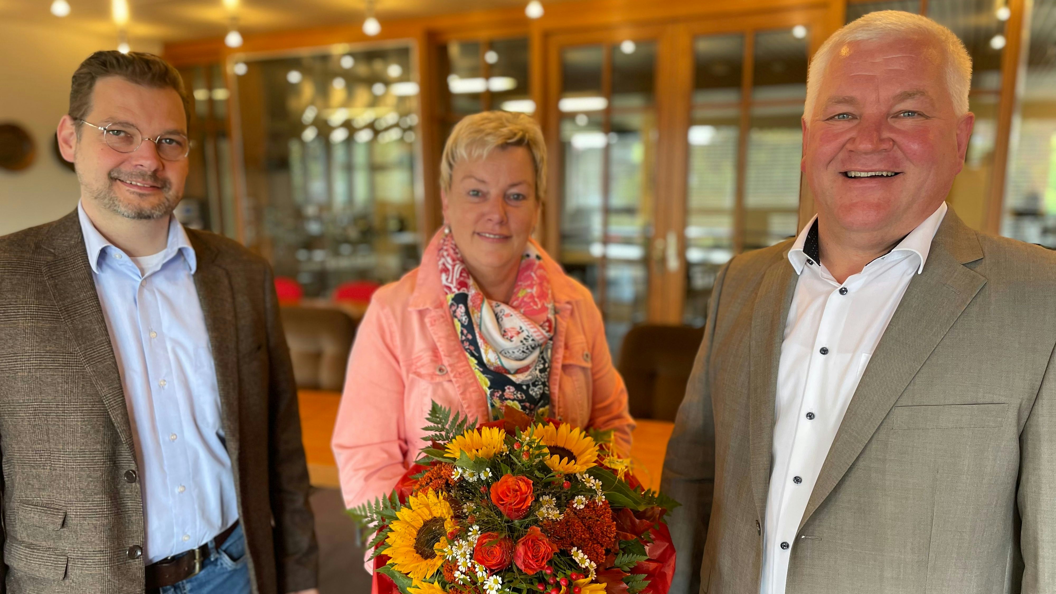 Blumen zur Begrüßung: Bürgermeister Burkhard Sibbel (rechts) und Erster Stadtrat Thomas Willen heißen Petra Brümmer im Rathaus willkommen. Foto: G. Meyer