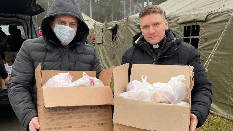 Mit Lebensmittelpaketen im Flüchtlingslager: Roman Raszko (links), Direktor der Caritas Grodno, zusammen mit einem Geistlichen. Foto: Caritas Grodno/Belarus