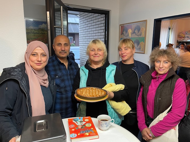 Zeichen des Dankes: Die Ukrainerin Olena Gumakova überreicht den Helfern (von links Sawsan Alzare und Raad Aldakhail) einen frisch gebackenen Kuchen. Foto: Meyer