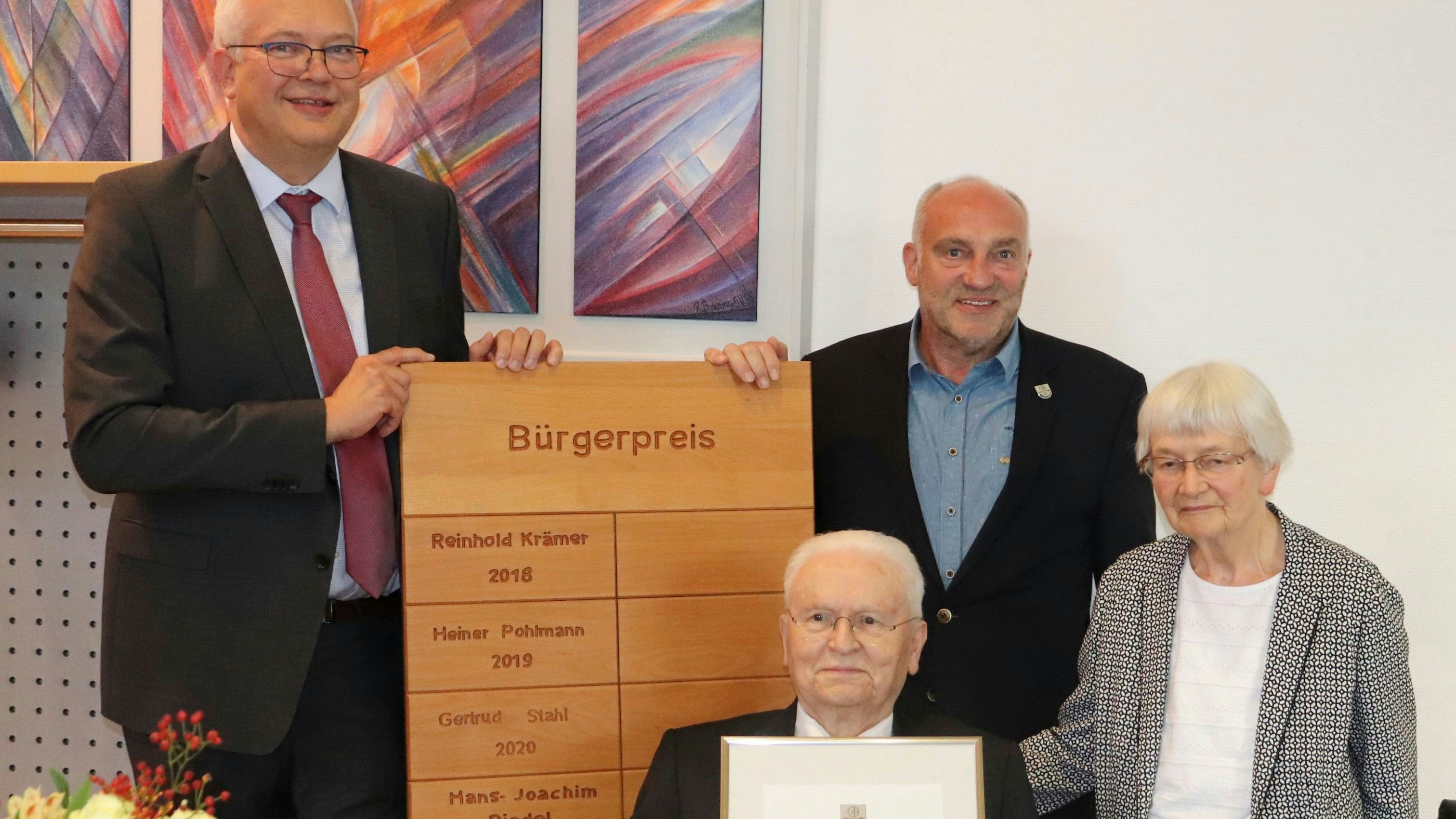 Der Preisträger 2021: Hans-Joachim Riedel (vorne, hier mit seiner Frau Maria) nahm die Urkunde im Oktober 2021 von Bürgermeister Ansgar Brockmann (links) und dem damaligen stellvertretenden Bürgermeister Rainer Duffe entgegen.&nbsp; Foto: Schulz