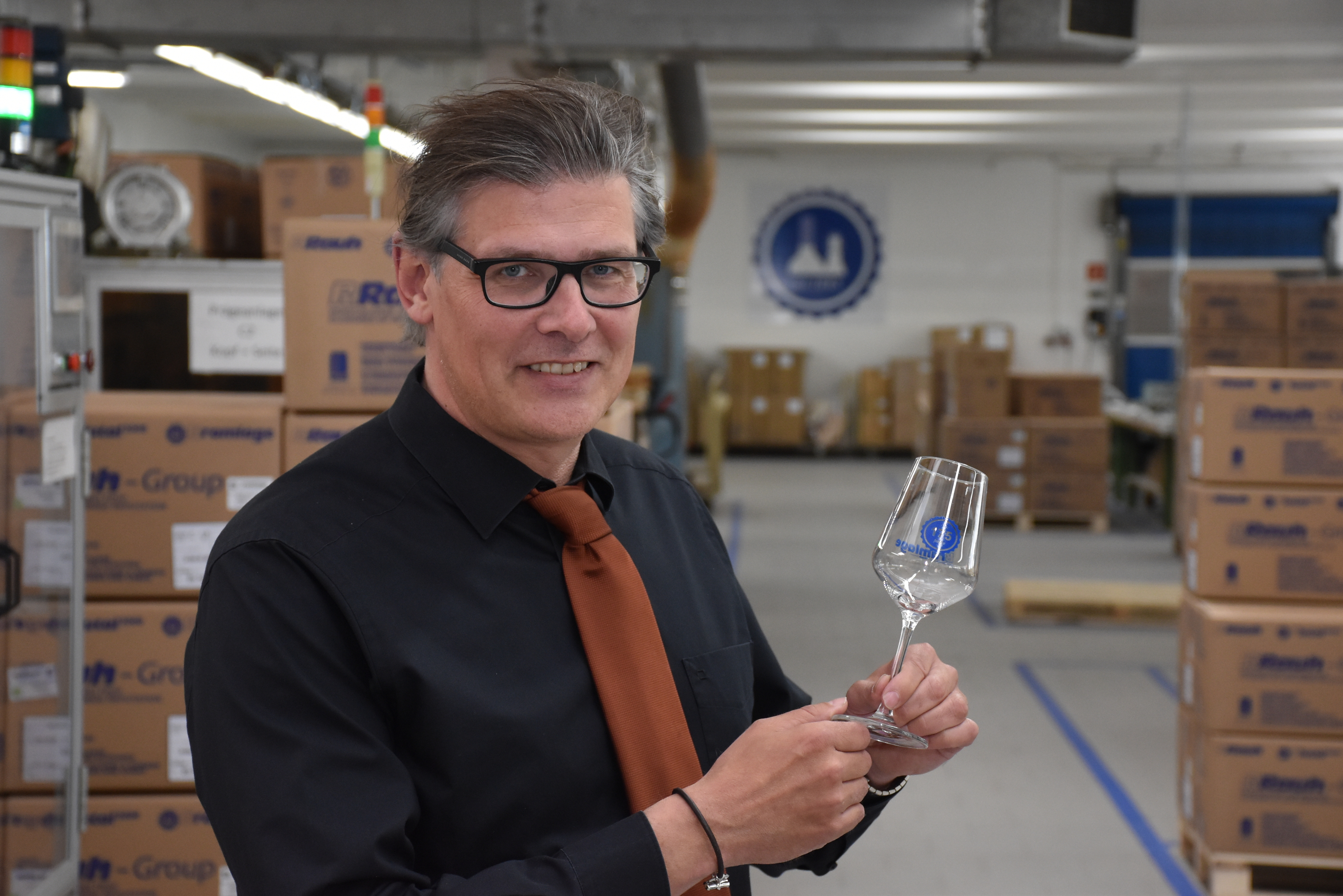 "175 Jahre sind schon eine Hausnummer": Bramlage-Geschäftsführer Peter Blossey mit einem Jubiläums-Weinglas. Foto: Timphaus