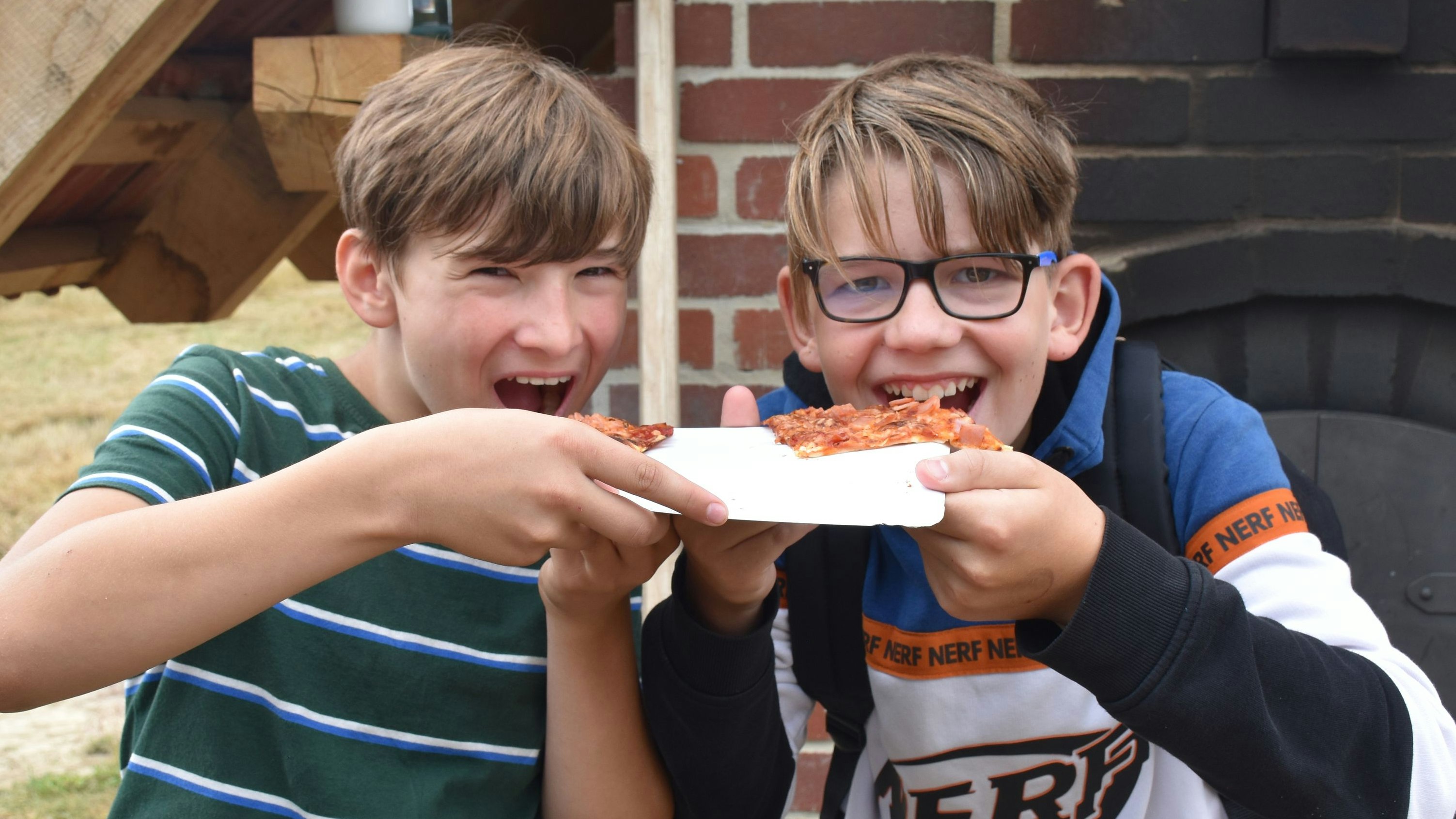 Lecker! Maxim Bechtold (links) und Julian Thiele aus der 6a genießen die Pizza aus dem Backofen. Foto: Böckmann