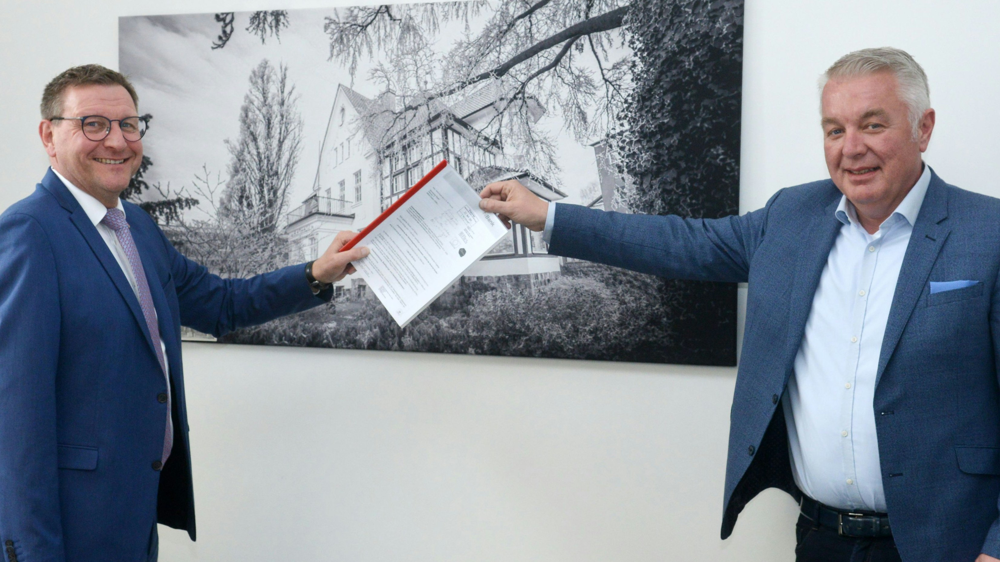 Christoph Eilers (rechts) überreicht Bürgermeister Kressmann den Förderbescheid über 1,6 Millionen Euro für das Gewerbegebiet „Osteressen". Foto: Siemer