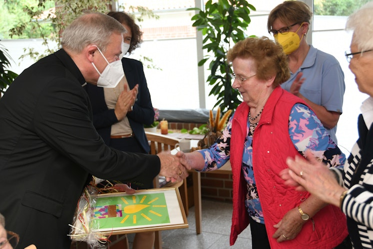 Herzlicher Empfang: Gertrud Heidkamp (rechts) überreicht Weihbischof Theising ein Geschenk bei dessen Besuch. Foto: LCV-Oldenburg