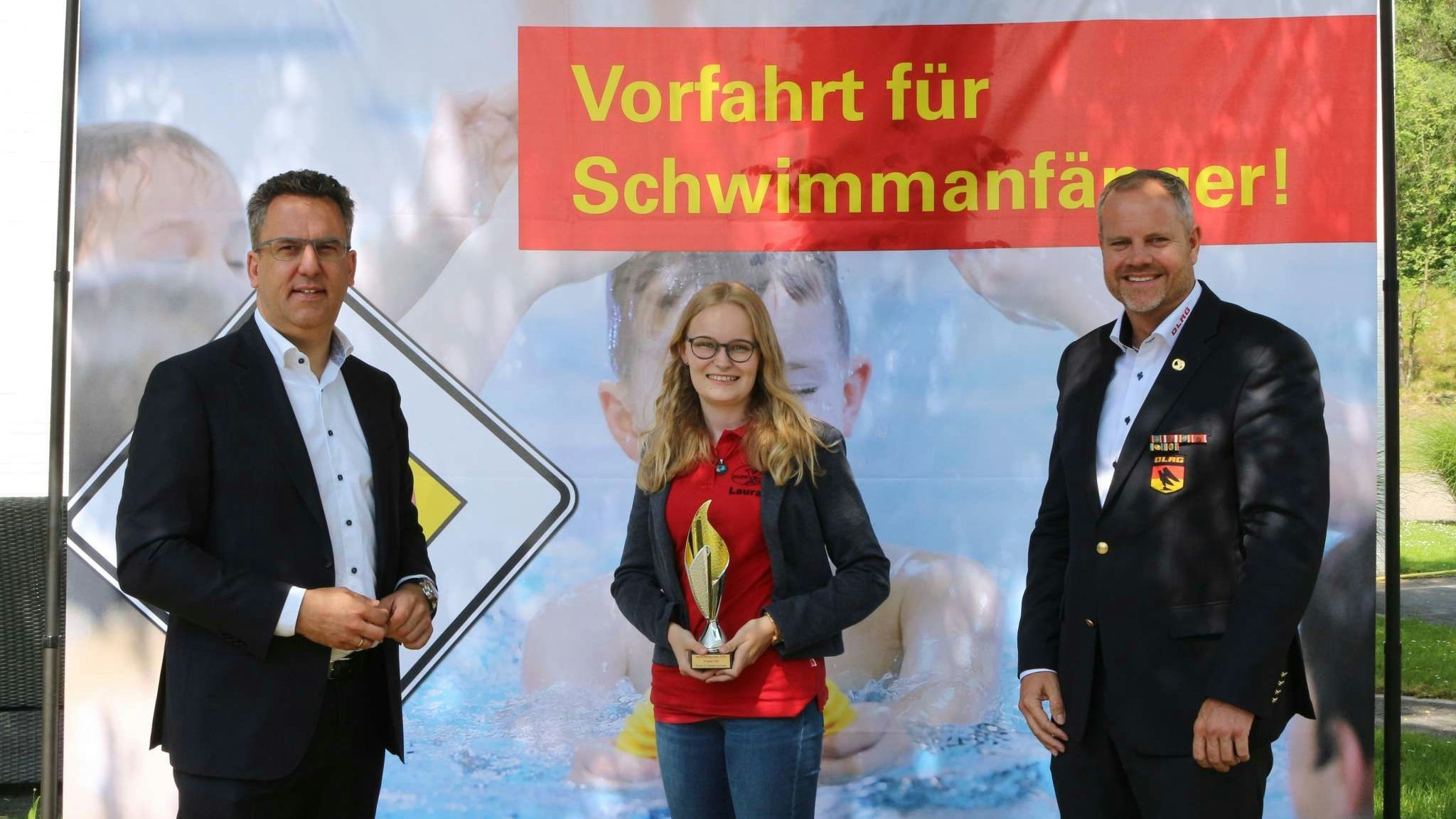 Stolz auf die Auszeichnung: Die Technische Leiterin Laura Rohe nahm einen kleinen Pokal von Präsident Oliver Liersch (links) und dem Vizepräsidenten Hendrik Schultz entgegen. Foto: DLRG