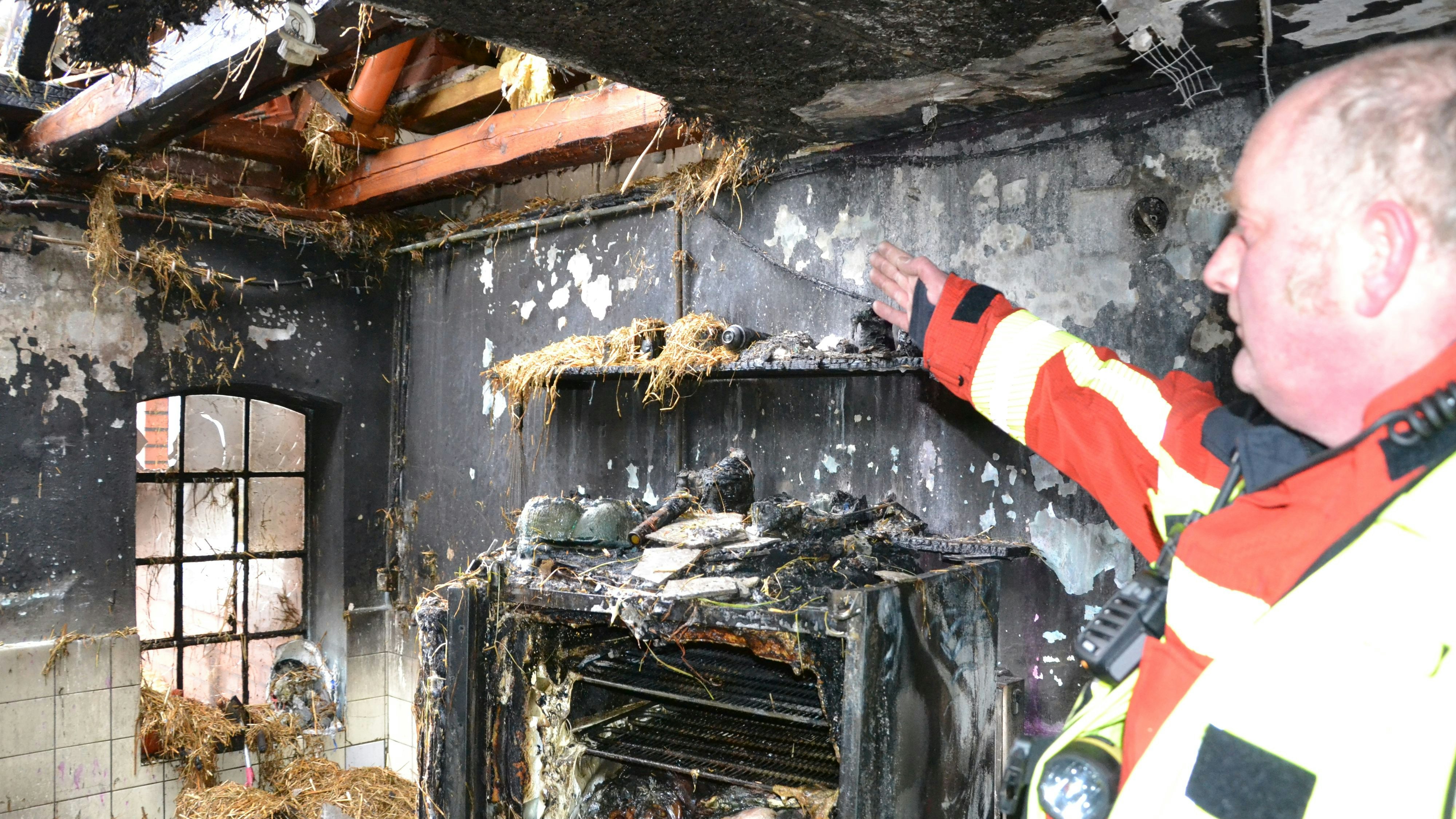 Schwer zerstört: Einsatzleiter Torsten Koopmeiners erklärt, wie es zu dem Brand kam. Foto: Meyer