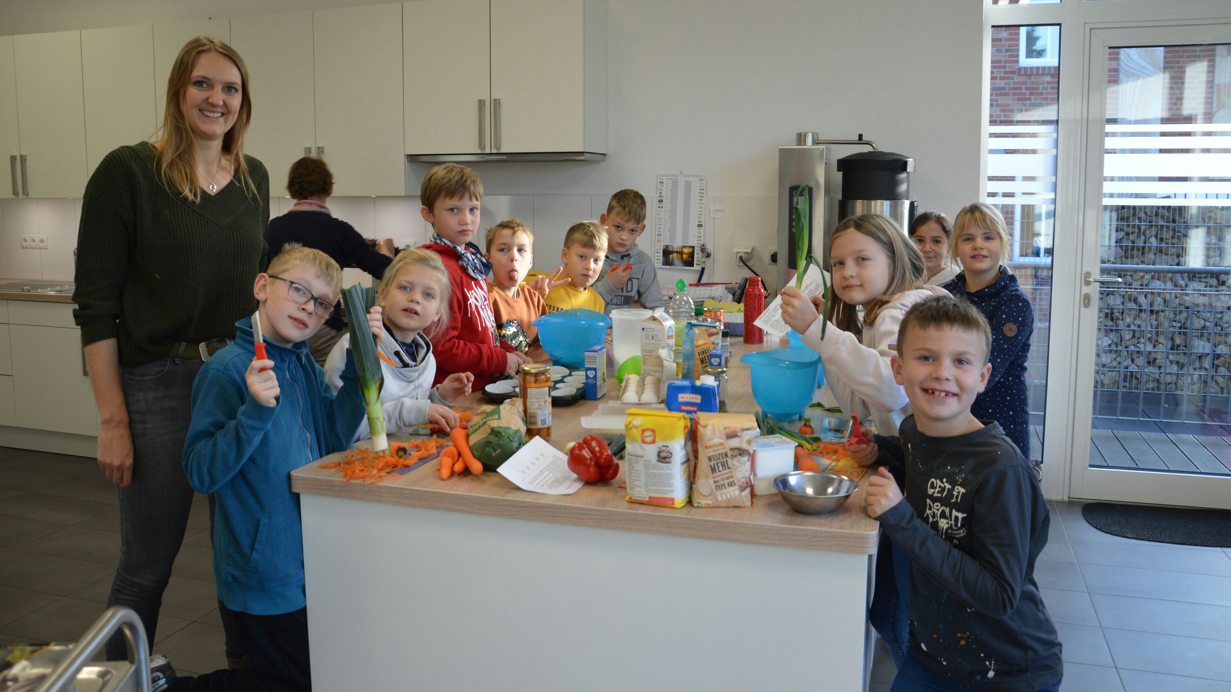 Mit Freude am Kochen: Maria Kalvelage (links) und die Drittklässler der Grundschule Evenkamp schnippeln, was das Zeug hält. Foto: Wienken
