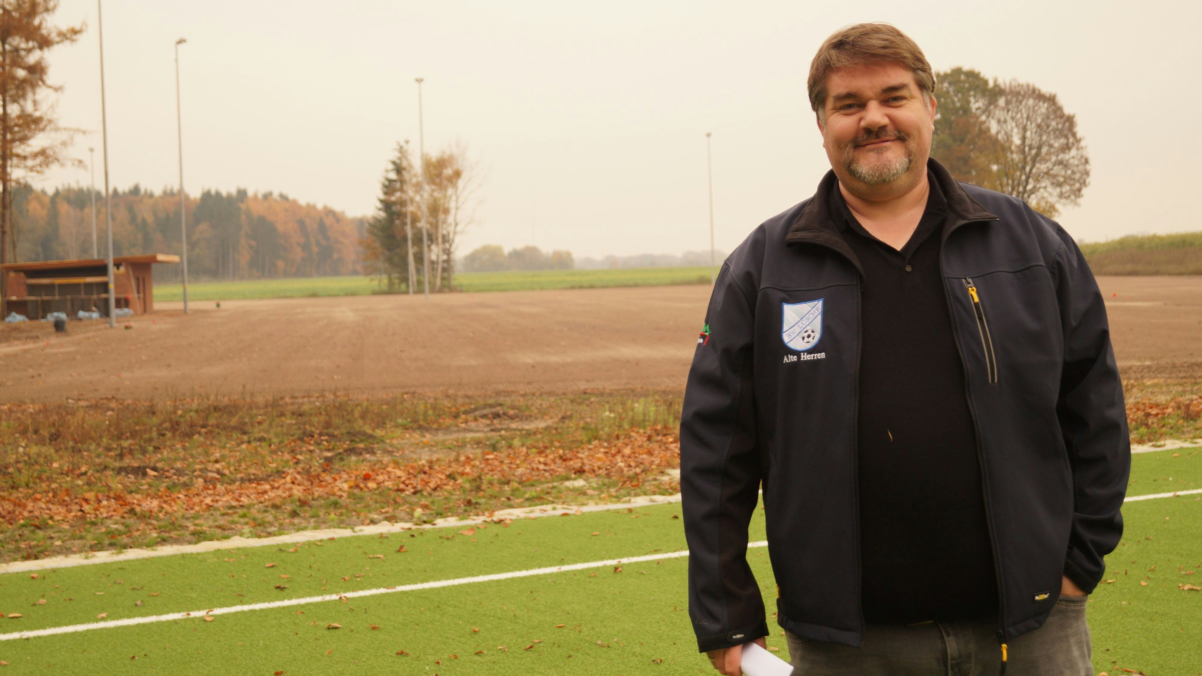 Begleitet das Projekt: Oliver Suding ist Vorsitzender des SV Blau-Weiß Lüsche. Er freut sich bereits darauf, wenn das neue Sportzentrum im kommenden Jahr fertig ist. Den Kunstrasenplatz kann er schon betreten. Hinter ihm entstehen zwei große Naturrasenplätze. Foto: C. Meyer