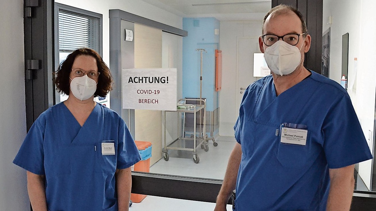 Streng getrennt: Die Intensivpfleger Kerstin Meyer und Michael Puncak stehen vor dem Eingang zum Covid-Bereich. Foto: Meyer