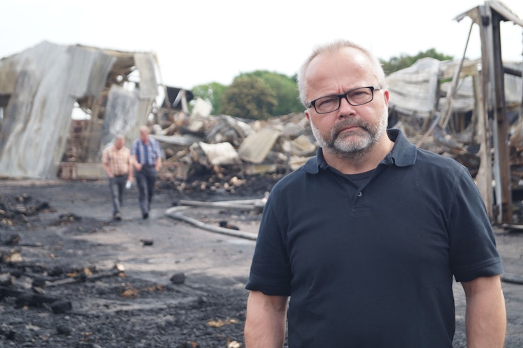 Vor den Trümmern auf seinem Betriebsgelände: Geschäftsführer Michael Peters ist den Einsatzkräften sehr dankbar. Foto: C. Meyer