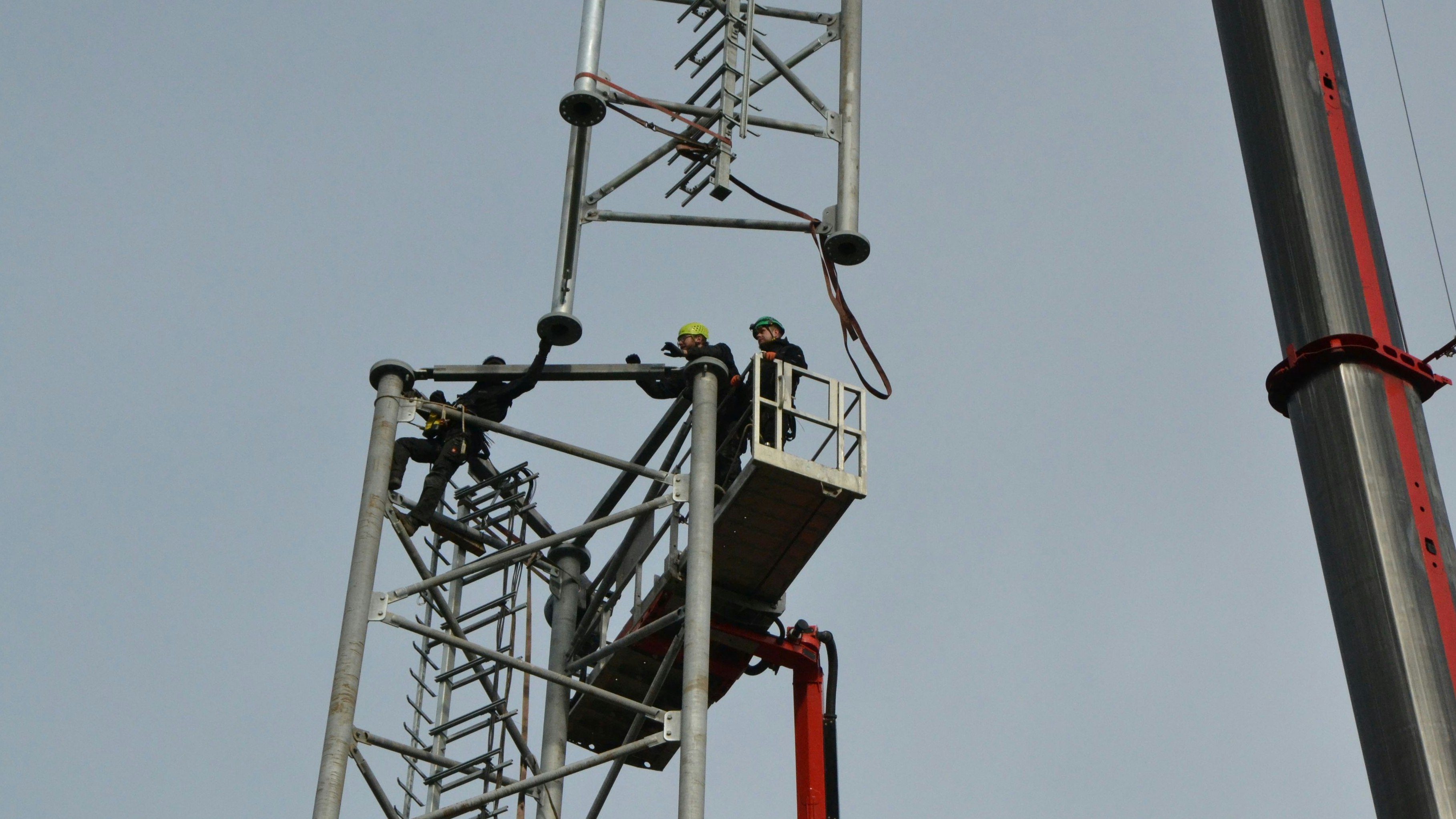 Handarbeit: Arbeiter setzen die beiden Teilstücke des Funkmastes in 40 Meter Höhe zusammen. Foto: G. Meyer