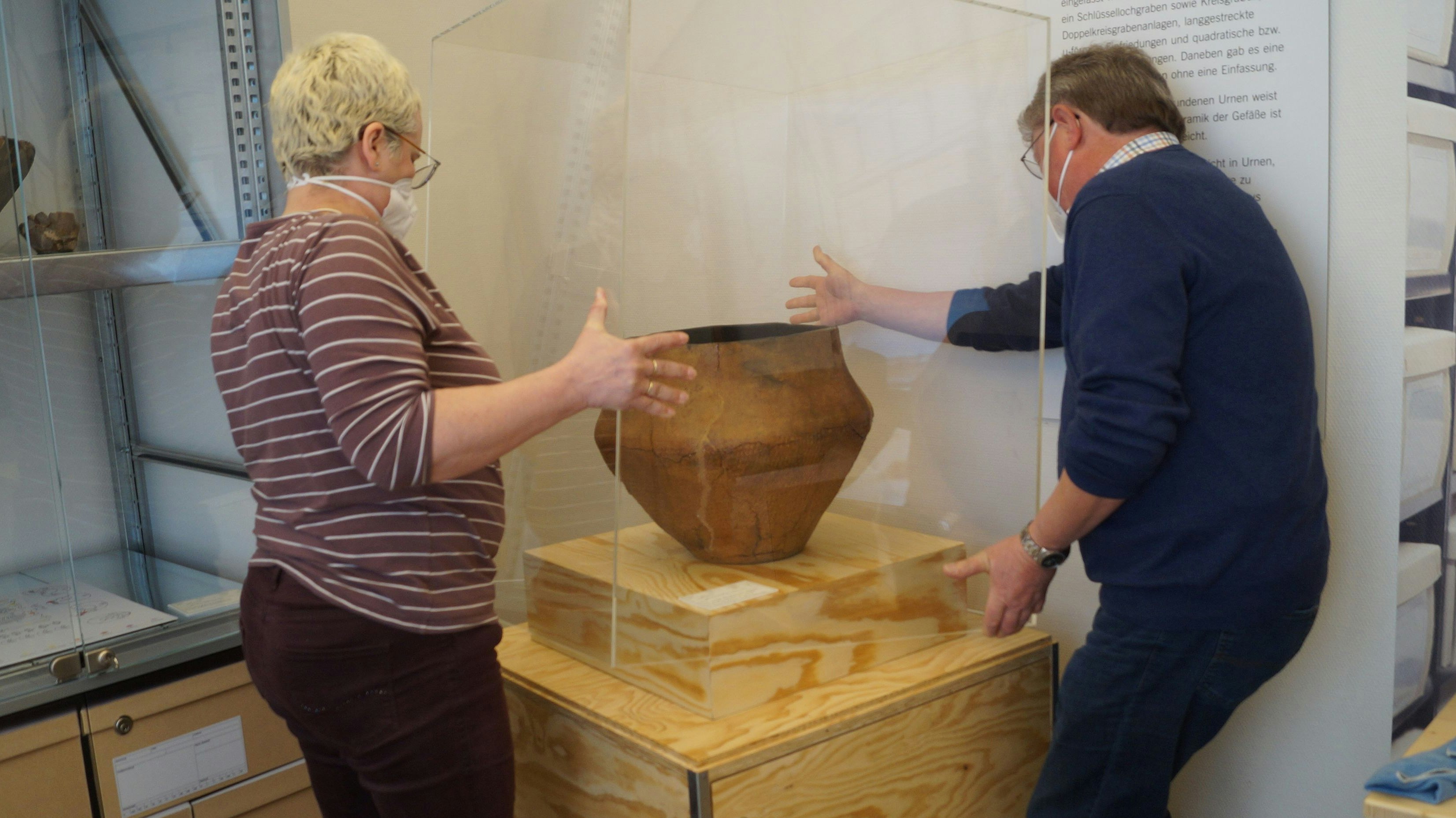 Rund 3.000 Jahre alt: Eine große Urne aus der Bronzezeit hat nun ihren Platz im ArchäoVisbek gefunden. Museumsberaterin Dr. Beate Bollmann und Manfred Gelhaus vom Heimatverein Visbek setzen das Fundstück angemessen in Szene. Foto: C. Meyer