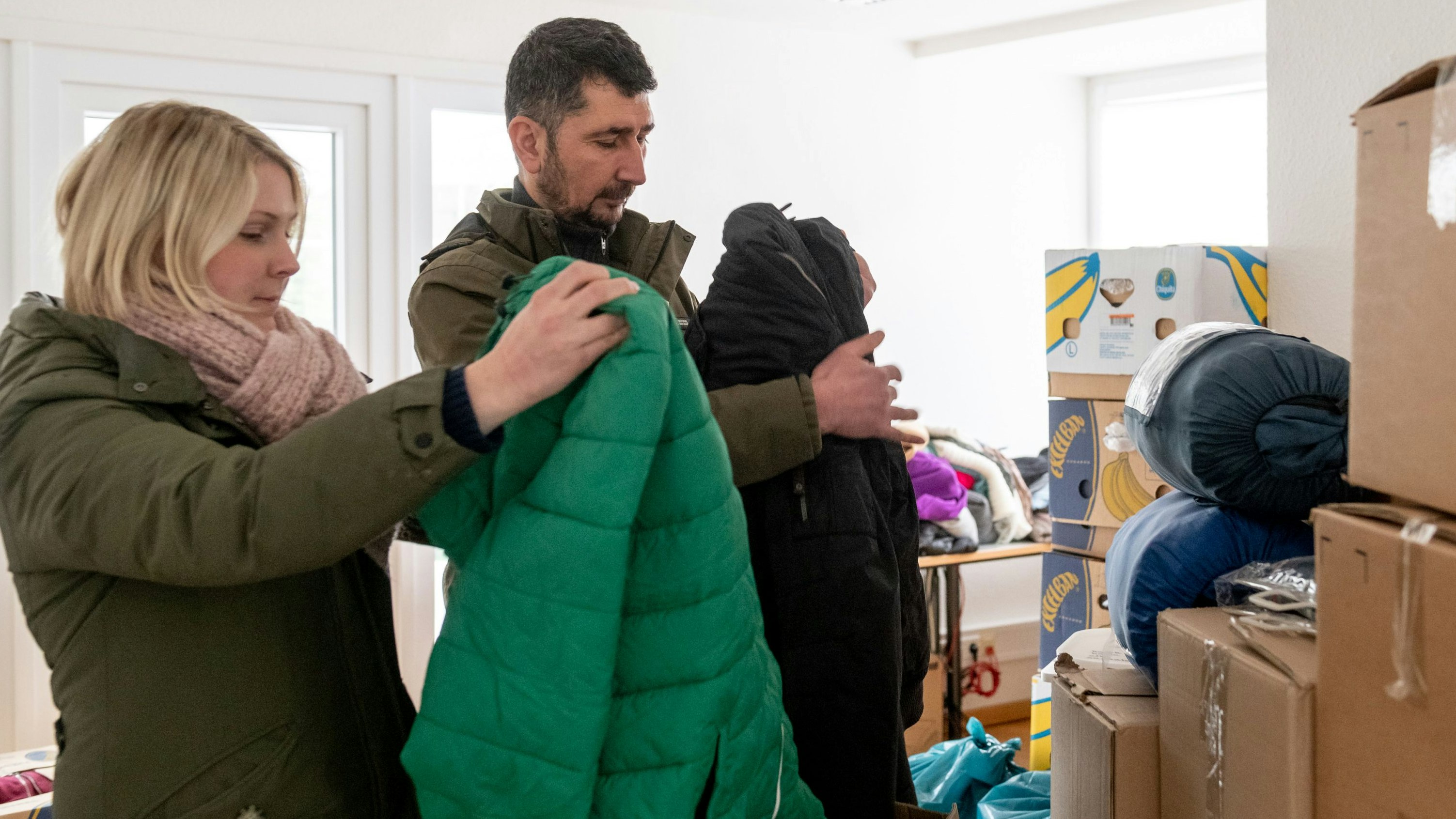 Unerwartet viele Spenden: Christina Voss und Ferdi Karatas packen Kleidung in Kartons. Foto: Chowanietz
