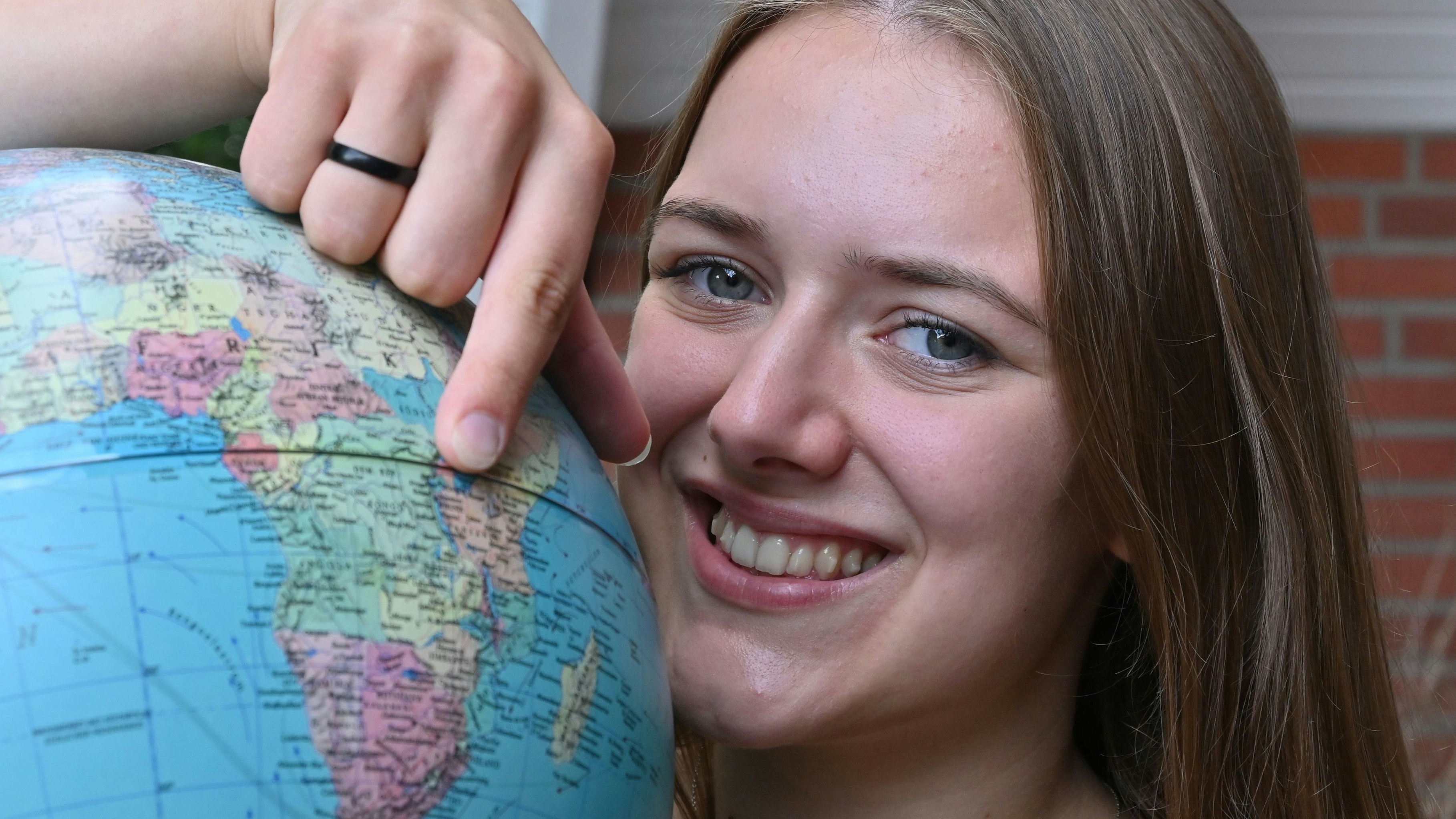 Da geht's hin: Johanna Rump zeigt auf dem Globus, wo sie die kommenden 12 Monate leben wird. Foto: Vorwerk