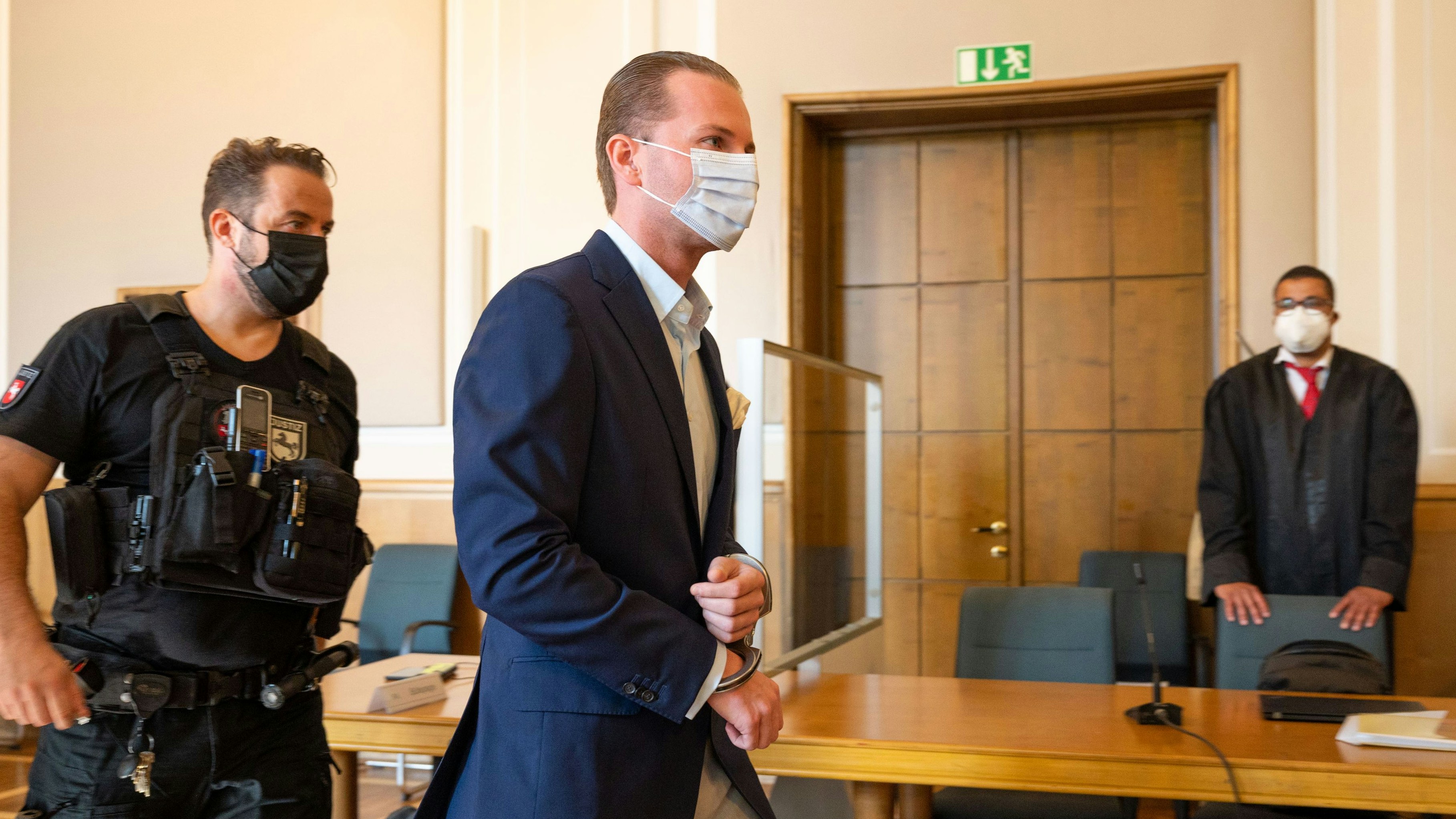 Sakko mit Einstecktuch: Nobel gekleidet, aber in Handschellen wird Hendrik Holt in den Gerichtssaal geführt. Foto: M. Niehues
