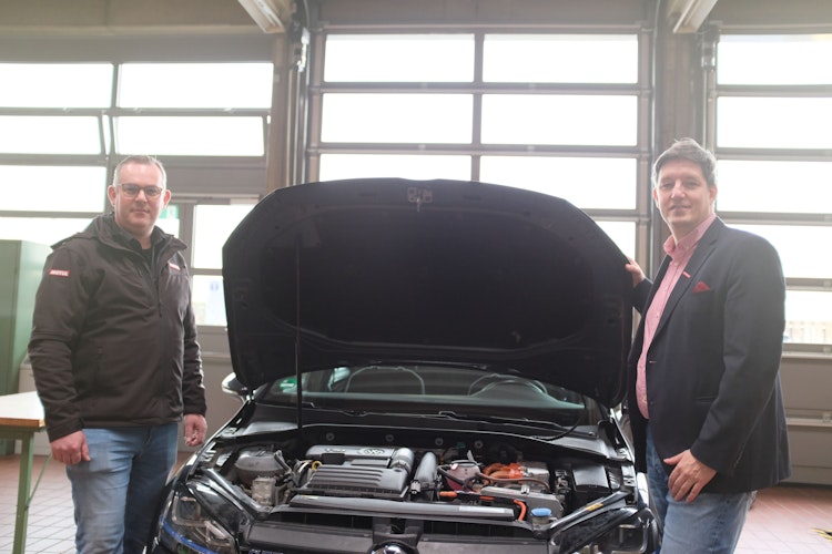 Christian Meyer (links) und Dr. Michael Hoffschroer stehen an einem VW-Hybridauto. Foto: Niemeyer