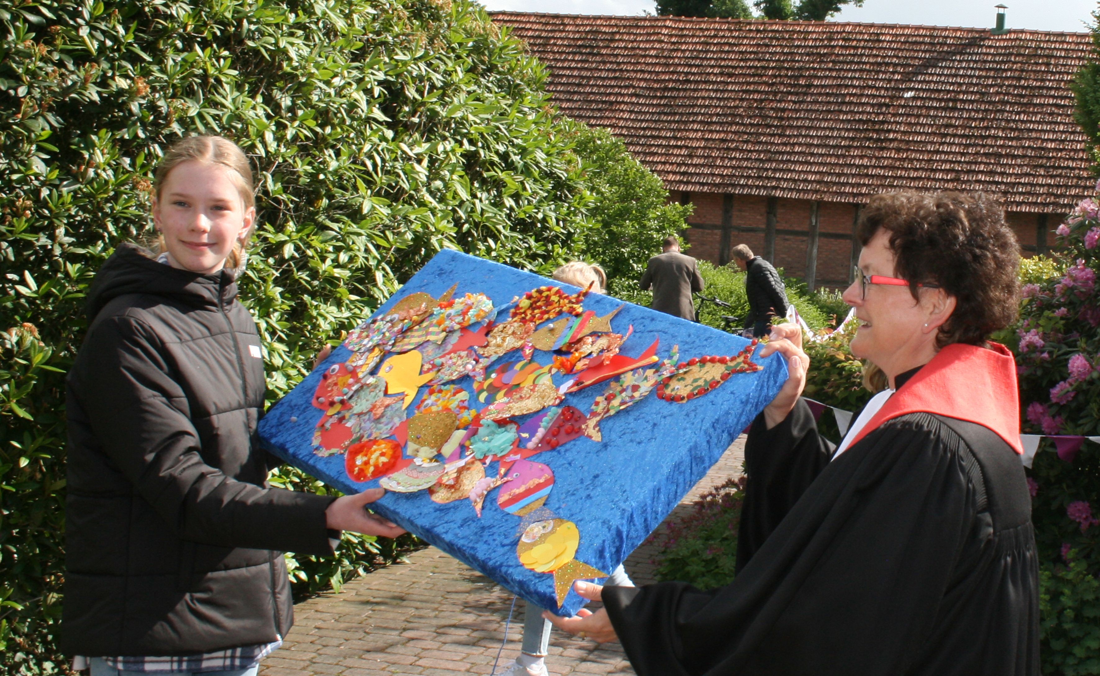 Die Kinder überreichten ein Kunstwerk der Pfarrerin Andrea Hilgen Frerichs. Foto: Klaus Esslinger