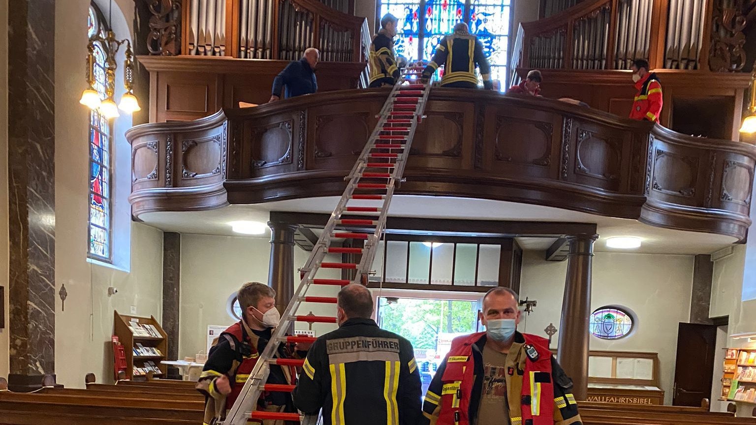 Über eine Leiterkonstruktion retten die Feuerwehrleute eine Kirchenbesucherin vom Orgelboden.&nbsp; Foto: Feuerwehr