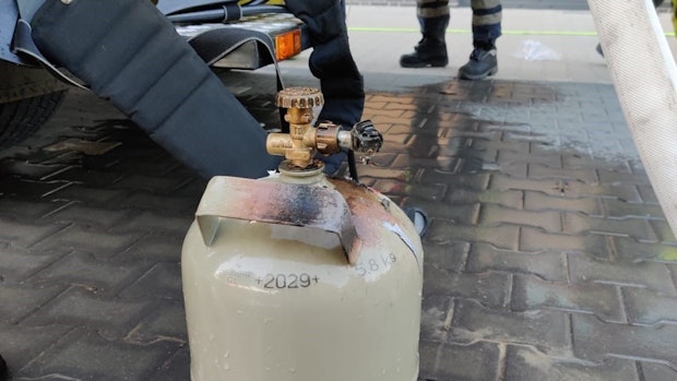 Bewohner dämmen Feuer von brennender Gasflasche ein