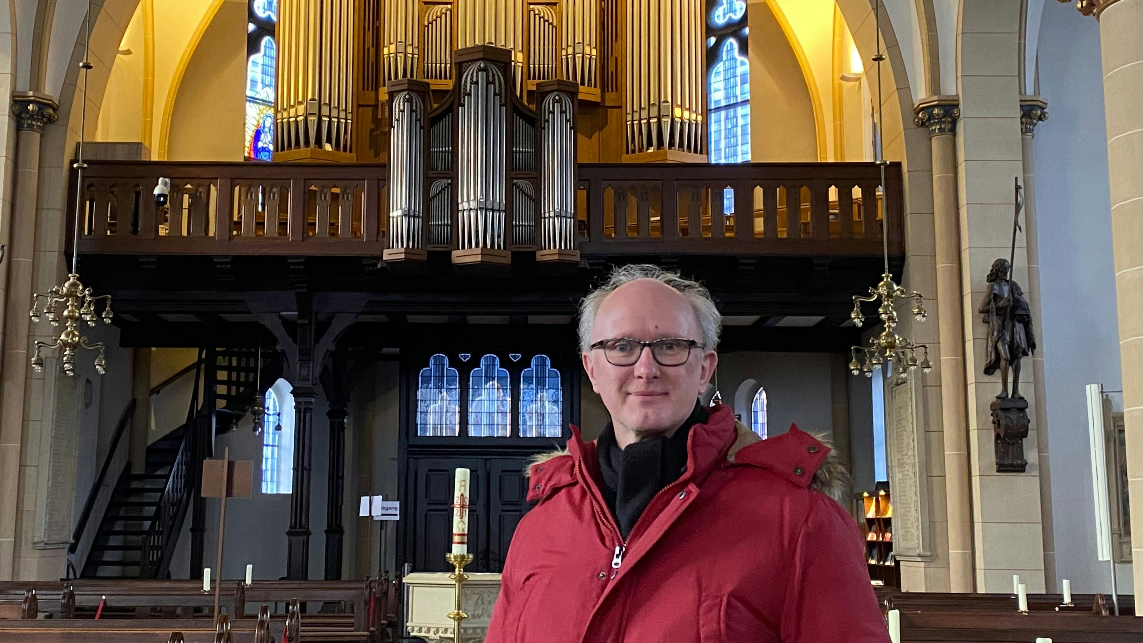 Mit der Sauerorgel im Hintergrund: Diplom-Kirchenmusiker Heinrich Deboi in der Friesoyther Pfarrkirche. Foto: Wimberg