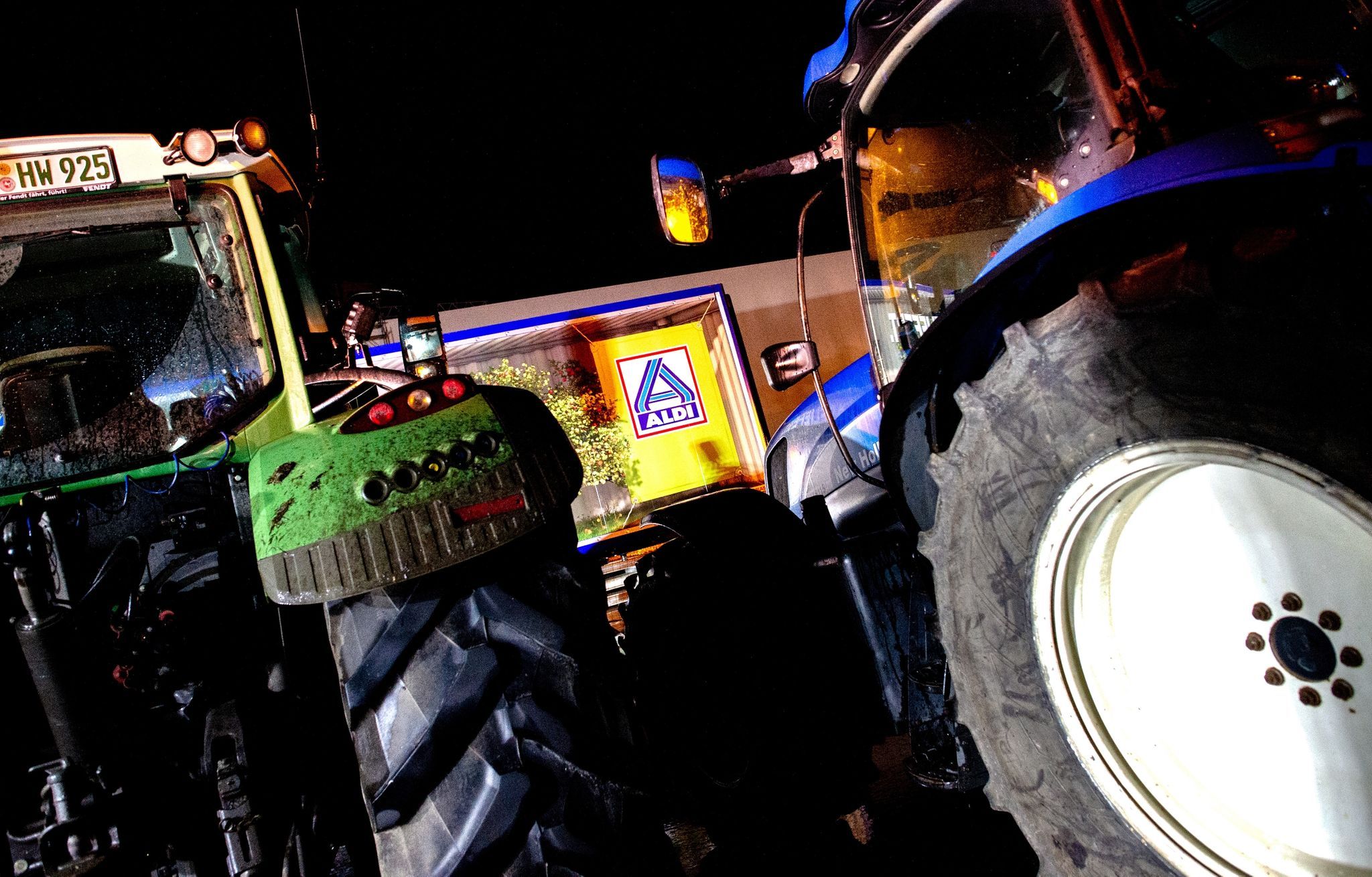 Traktoren stehen vor einem Lkw in der Zufahrt zum Zentrallager von Aldi. Foto: dpa/Dittrich