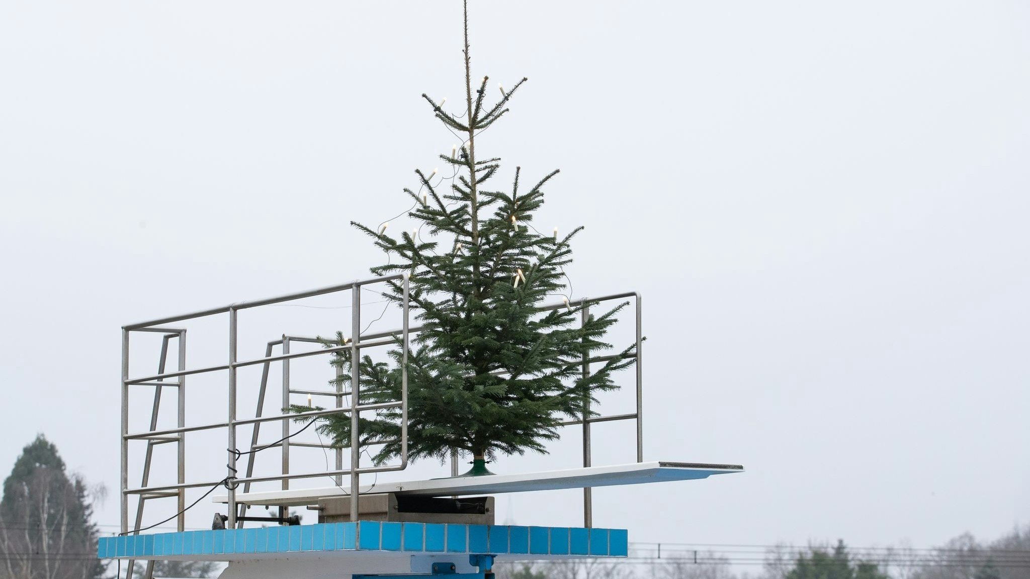 Ein Weihnachtsbaum steht auf einem Sprungturm im Freibad in Bohmte. Foto: dpa/Gentsch