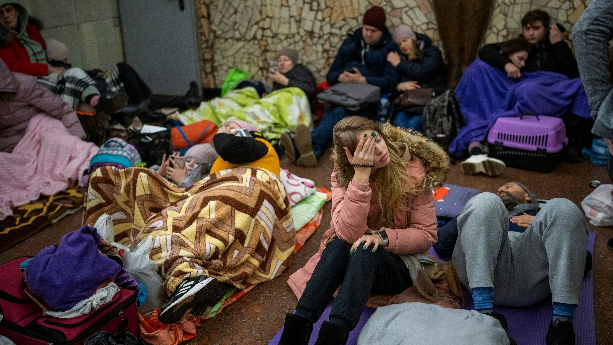 Menschen sitzen und liegen in einer U-Bahn-Station in Kiew. Foto: Emilio Morenatti / AP / dpa