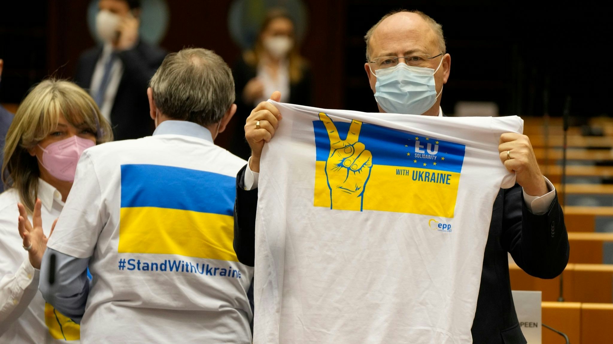 Ein Mitglied des Europäischen Parlaments hält ein T-Shirt in den Farben Blau und Gelb zur Unterstützung der Ukraine. Foto: Mayo