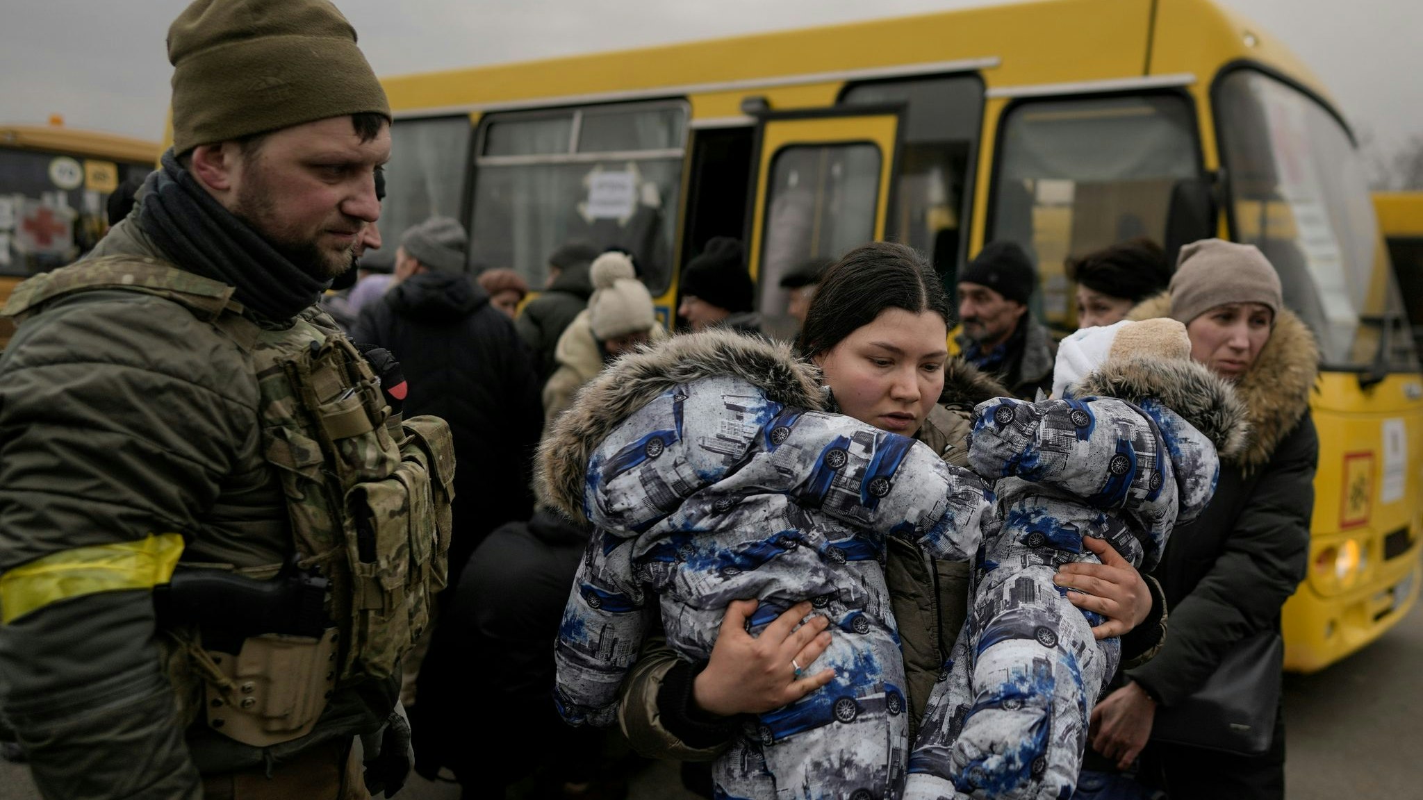 Eine Frau flieht mit zwei Babys aus der ukrainischen Hauptstadt Kiew. Foto: Vadim Ghirda / AP / dpa