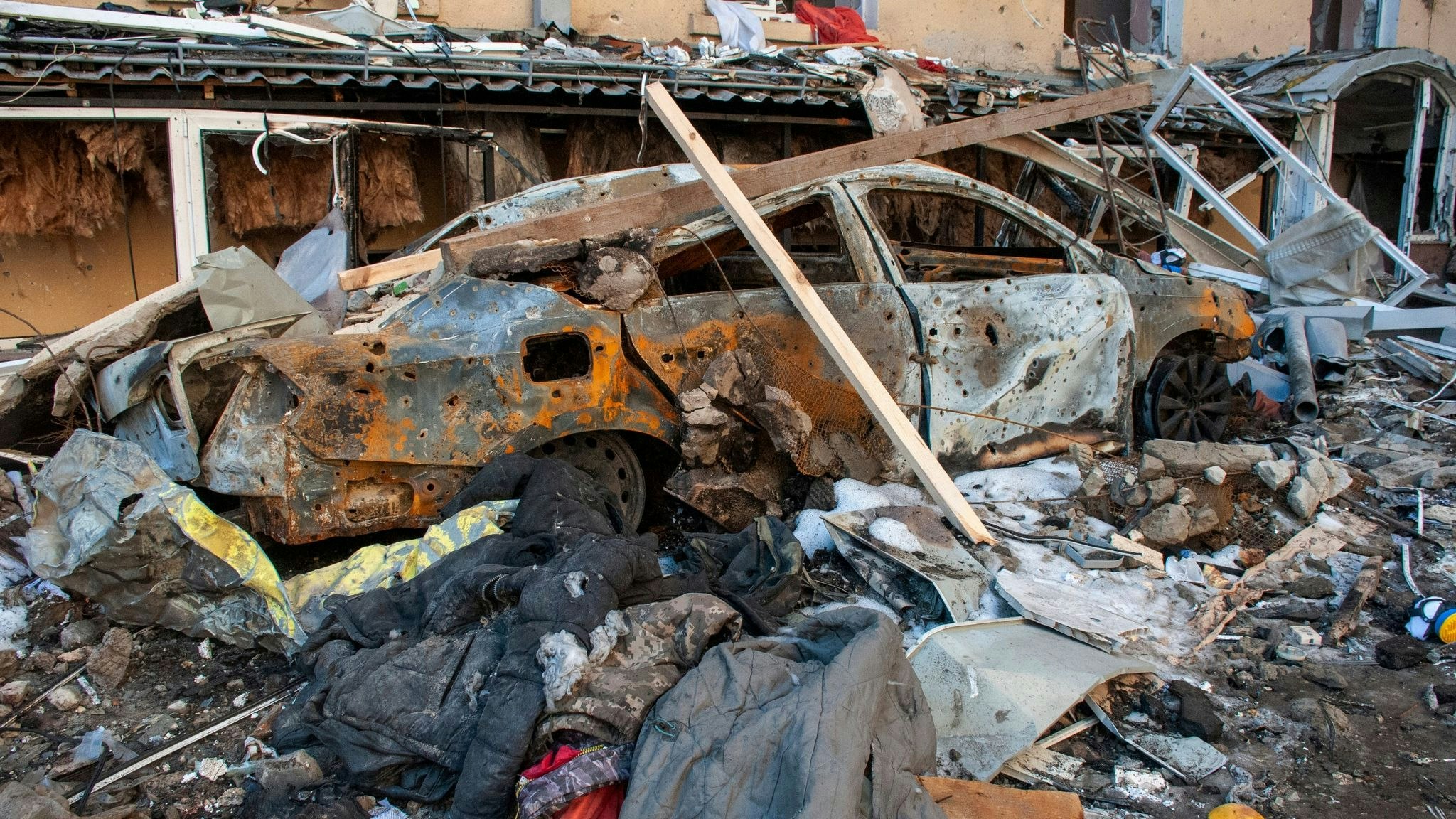 Ein durch Granatenbeschuss zerstörtes Auto steht auf einer Straße. Foto: dpa/Marienko/AP