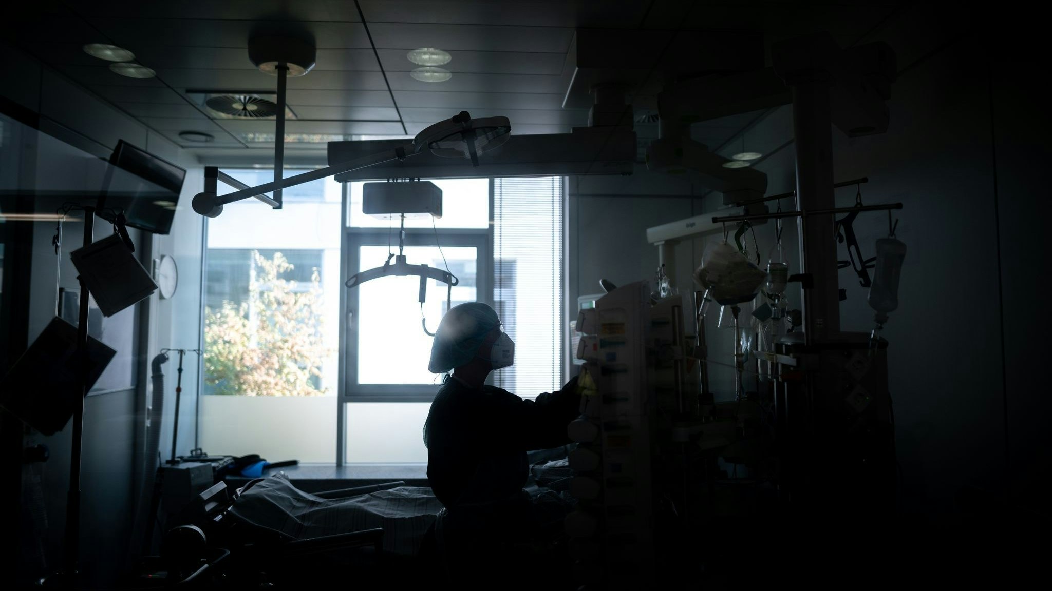 Eine Mitarbeiterin der Pflege steht in einem Zimmer einer Corona-Intensivstation. Foto: dpa/Strauch