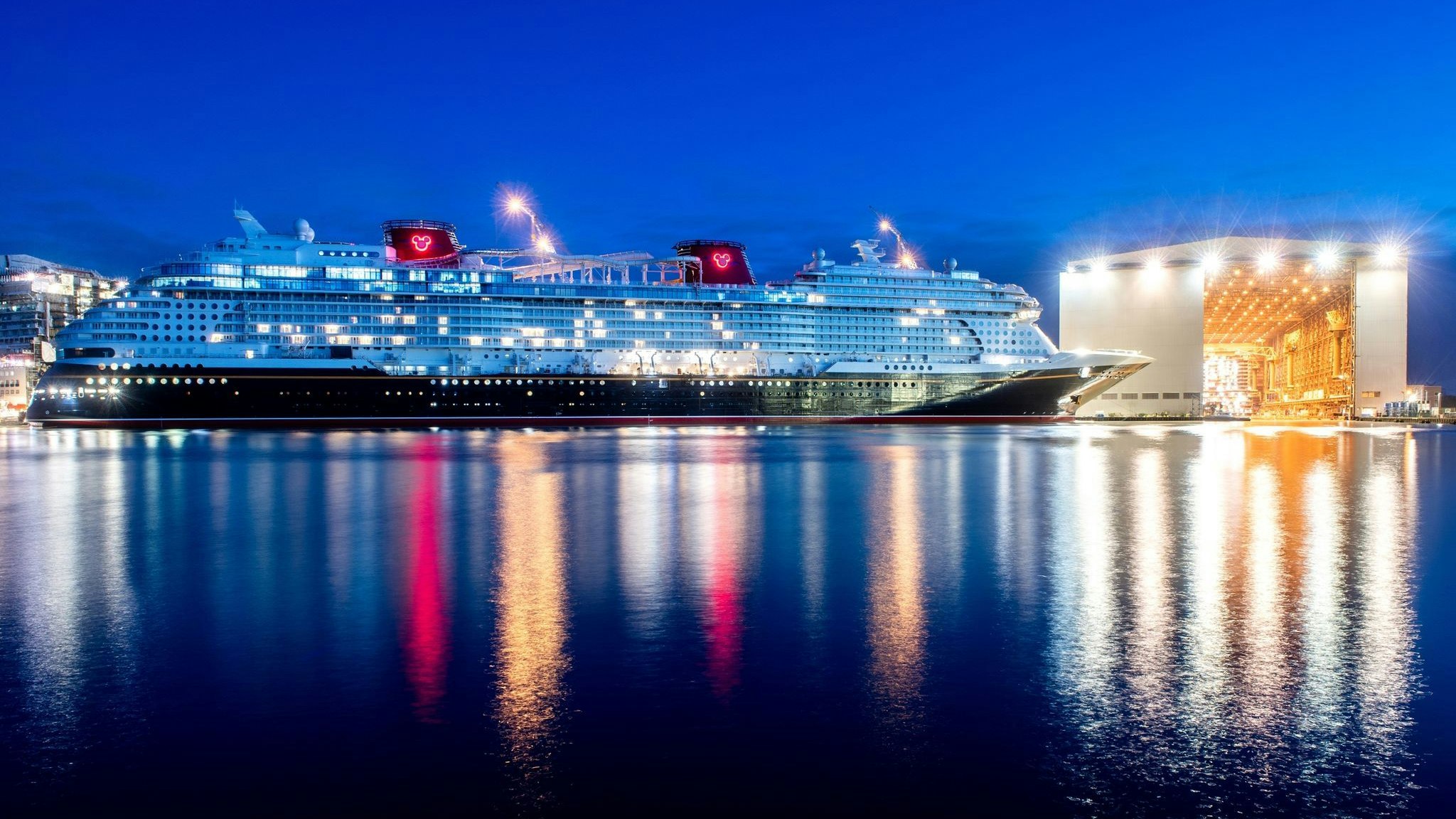 Das Kreuzfahrtschiff „Disney Wish“ liegt in der Dämmerung am Ausrüstungskai der Meyer Werft. Foto: dpa/Dittrich