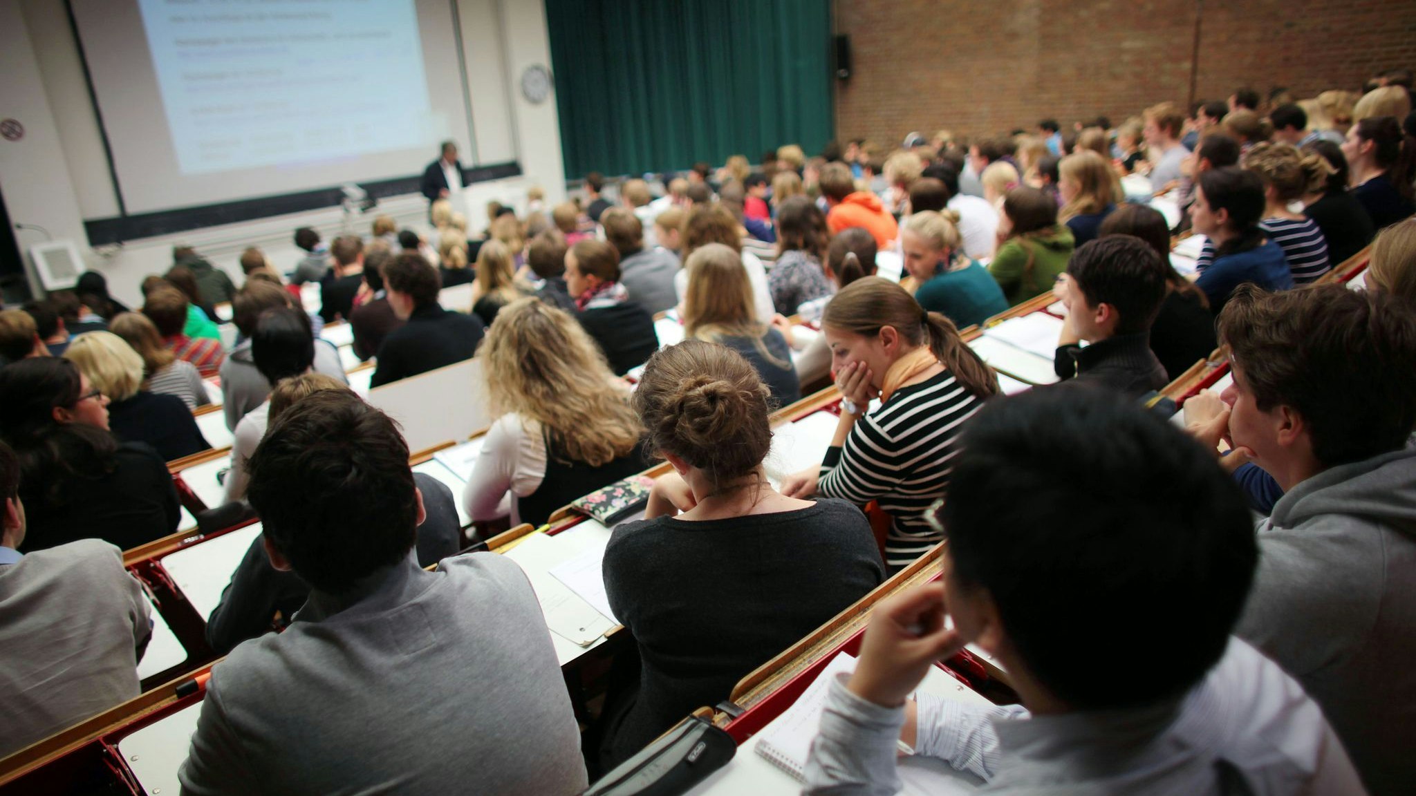 Studierende verfolgen eine Vorlesung an der Universität Köln. Bafög-Empfänger sollen zum Wintersemester fünf Prozent mehr Geld bekommen. Foto: dpa/Berg