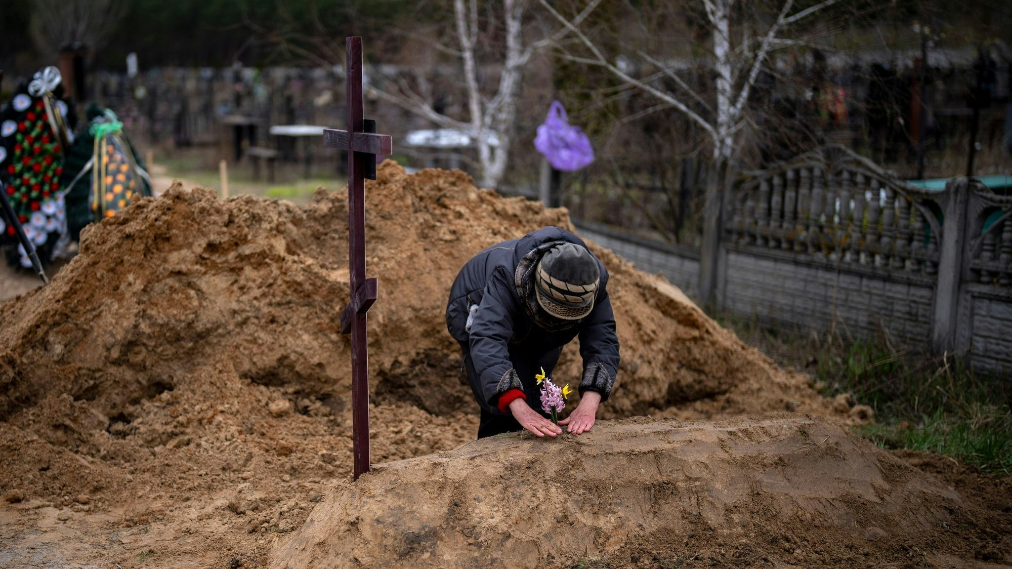 Die 63-jährige Vera Ptitsyna legt Blumen auf das frische Grab ihres Mannes Jurij Ptitsyn: Der 74-Jährige starb während der einmonatigen russischen Besetzung von Butscha, wegen mangelnder medizinischer Versorgung. Foto: dpa/Morenatti/AP